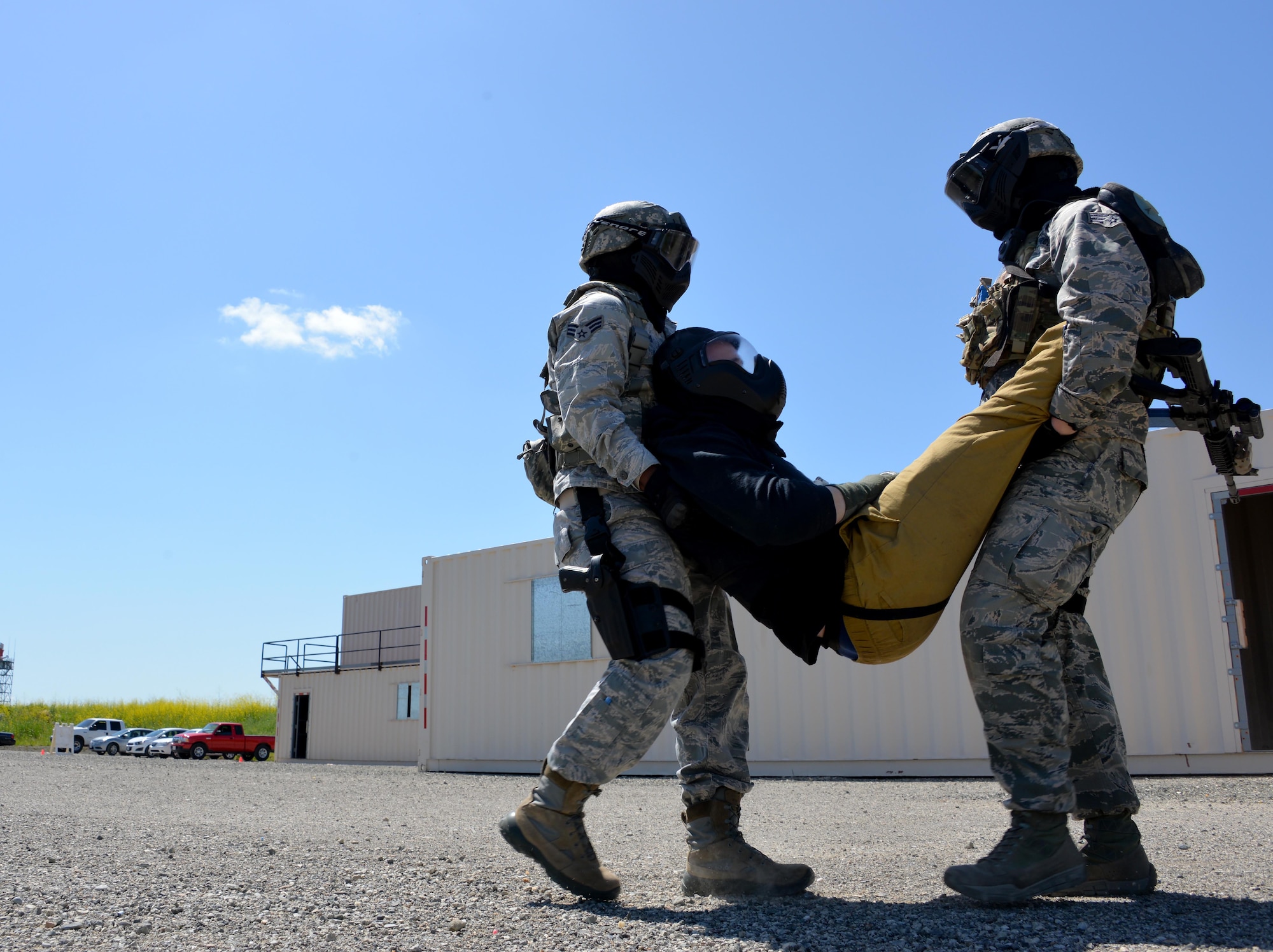 Two Airmen assigned to the 60th Security Forces Squadron carry out a simulated casualty during an active shooter training event April 13, 2016, at Travis Air Force Base, California. During the training event, Airmen had to properly identify, secure, and protect several bystanders who moved throughout the buildings. (U.S. Air Force photo by Staff Sgt. Charles Rivezzo)