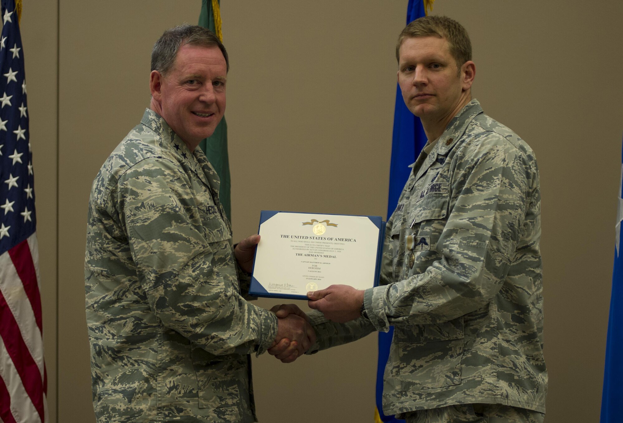 Maj. Matthew Arnold, right, the 336th Training Group chief of standards and evaluations, receives the Airman’s Medal during a ceremony April 8, 2016, at Fairchild Air Force Base, Wash. In 2013, Arnold and Tech. Sgt. Dean Criswell, the 22nd Special Tactics Squadron NCO in charge of rescue operations, were participating in a routine training exercise in Okinawa, Japan, when an HH-60G Pave Hawk went down. They helped save three of the four Airmen on the helicopter. (U.S. Air Force photo/Airman 1st Class Sean Campbell)