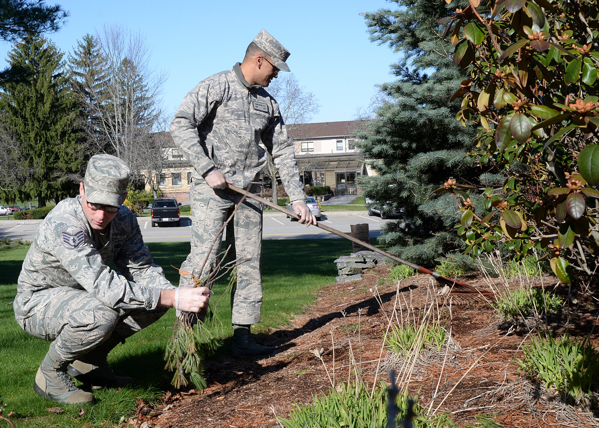 Staff Sgts. Lee Shortell and Christopher Feliz, both members of the Hanscom Patriot Honor Guard team, participate in a base cleanup near the POW/MIA display on Barksdale Street April 13. Base senior leaders organized the spring cleaning effort as a way to improve the appearance of the base after a long winter. (U.S. Air Force photo by Linda LaBonte Britt)