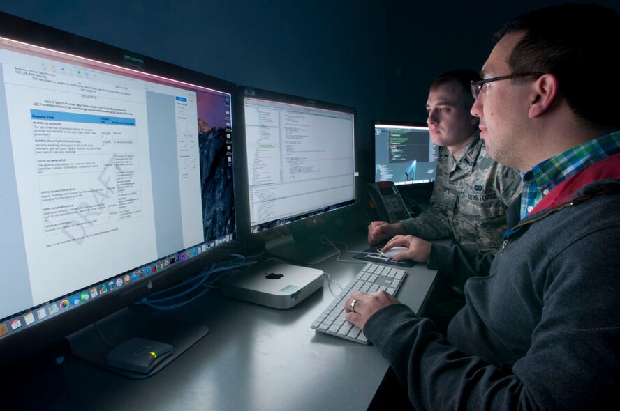 First Lt. Matthew Beasley, Distributed Common Ground/Surface System Integration
Backbone, or DIB, lead test engineer, reviews DIB integration results with test developer
Oscar Toro at the Hanscom Collaboration and Innovation Center, Hanscom Air
Force Base, Mass., April 12. The DIB provides a common set of services and
standards to facilitate the sharing of intelligence, surveillance and
reconnaissance information with the warfighter and the office at Hanscom is
celebrating the 11th anniversary of fielding software and plans to demonstrate
the current level of innovation by participating in several upcoming events.
(U.S. Air Force photo by Steve O'Neil)
