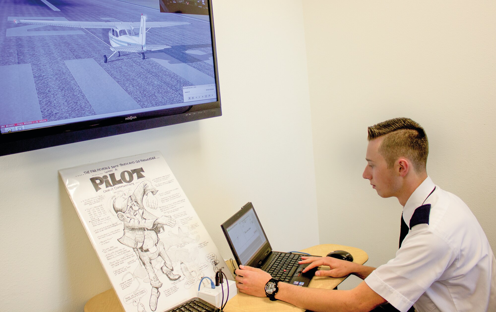High school senior Tristen Warner loads a program into the flight simulator from the instructor’s control console, dubbed the “Zeus Booth,” at the Southwest Aeronautics, Mathematics and Science Academy. (Photo by Bud Cordova)
