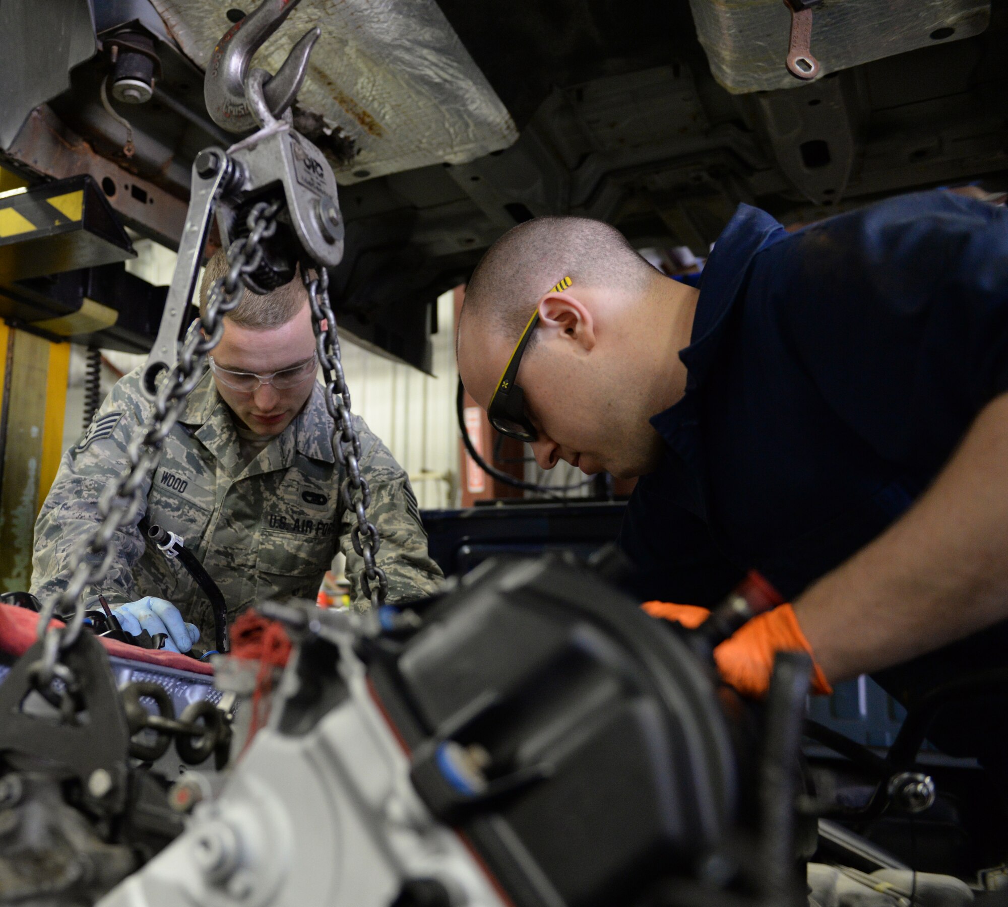 U.S. Air Force Staff Sgt. Chris Wood, (left) and Airman 1st Class Patrick Clifford move a new  Ford 5.4 liter V8 engine in a 2008 Ford F-150 pickup truck, April 14, 2016, Pease Air National Guard Base, N.H. The Airmen are special purposes vehicle technicians assigned to the Vehicle Maintenance Branch, 157th Logistics Readiness Squadron, New Hampshire Air National Guard. (U.S. Air National Guard photo by Staff Sgt. Curtis J. Lenz)