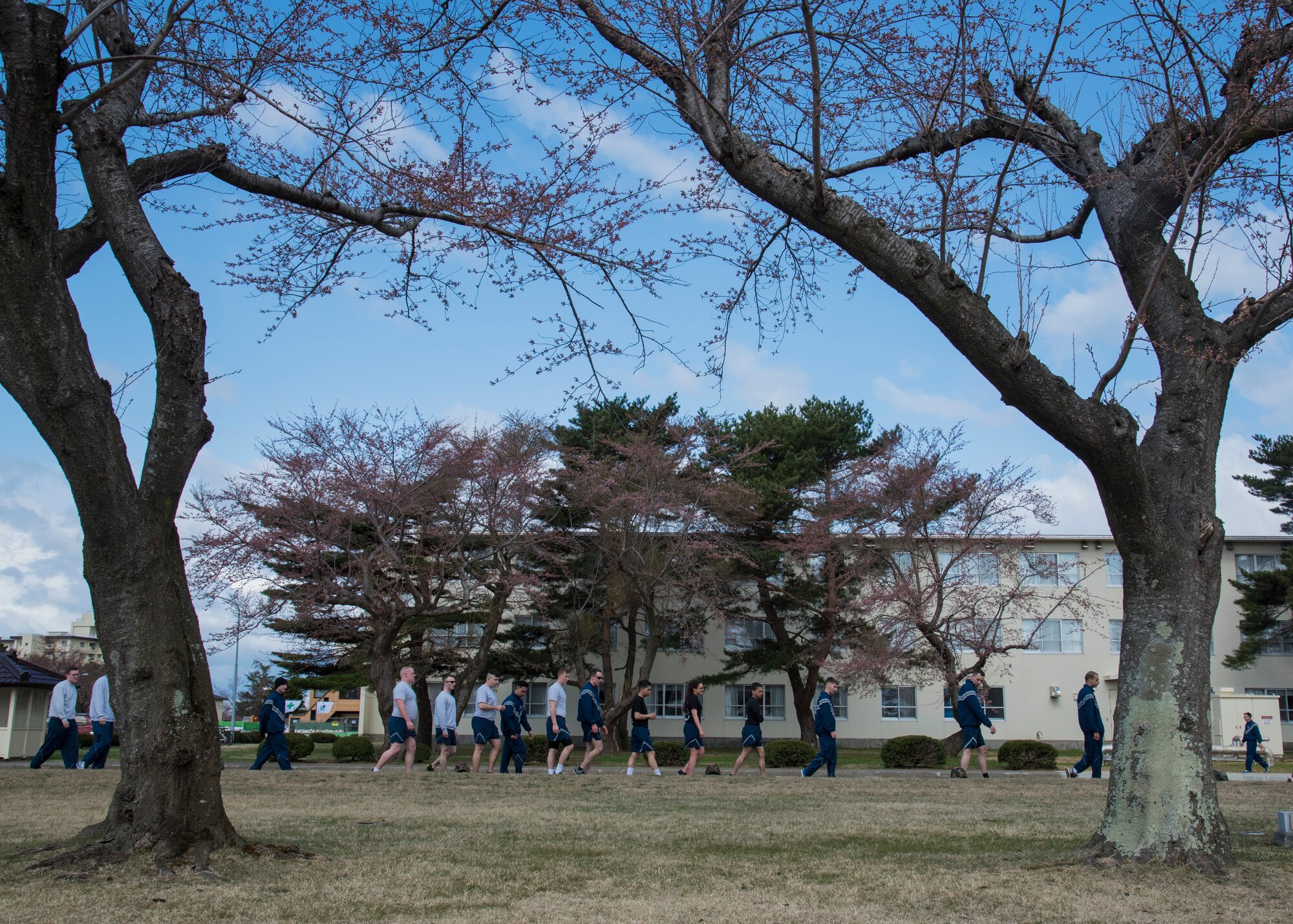 U.S. Air Force Airmen walk along Risner Circle during Resilient Airman Day at Misawa Air Base, Japan, April 15, 2016. After completing a 5K run, participants partook in a “Silent Walk” where helmets topped with red cards describing sexual assaults occurring during fiscal year 2015 and 2016 were placed. The event’s goal was to show this crime is an issue, even at Misawa, and to emphasize the necessity of caring for one’s wingman. (U.S. Air Force photo by Airman 1st Class Jordyn Fetter/Released)