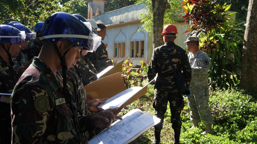 Members of Armed Forces Philippines listen to the mission briefing from Staff Sgt. Jim Evangelista from the Hawaii National Guard CERFP team for the collapsed structure shoring portion of the days activities for Balikatan 2016, April 09, 2016, Camp Capinpin, Philippines. The Hawaii National Guard CERF-P team is supporting Balikatian 2016 through the National Guard State Partnership Program with the aim of building capability across the disaster response forces of both countries. Balikatan, which means "shoulder to shoulder" in Filipino, is an annual bilateral training exercise aimed at improving the ability of Philippine and U.S. military forces to work together during planning, contingency and humanitarian assistance and disaster relief operations.