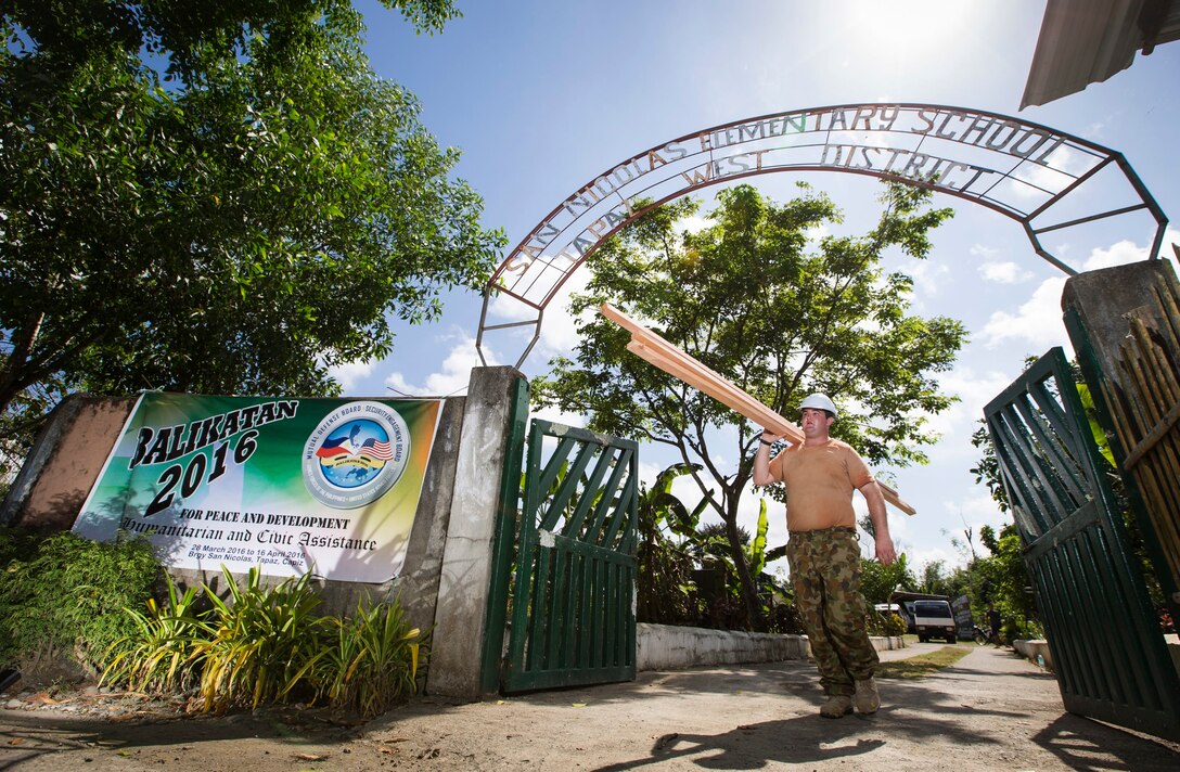 Australian Army Sapper Scott Nolan, a carpenter from 21 Construction Squadron, 6th Engineer Support Regiment, carries timber to be used for repairing a damaged school building during Exercise Balikatan 2016. 