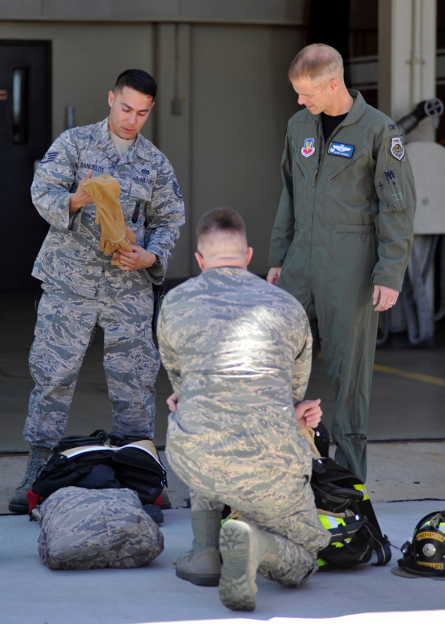Staff Sgt. Jacob Banuelos, 325th Civil Engineer Squadron lead firefighter (left), shows Col. Derek C. France, 325th Fighter Wing commander (right), fire protection gear April 8, 2016. Banuelos was chosen to be the Airman shadowed by the base commander for April as part of the Airman Shadow Program. (U.S. Air Force photo by Senior Airman Sergio A. Gamboa/Released)