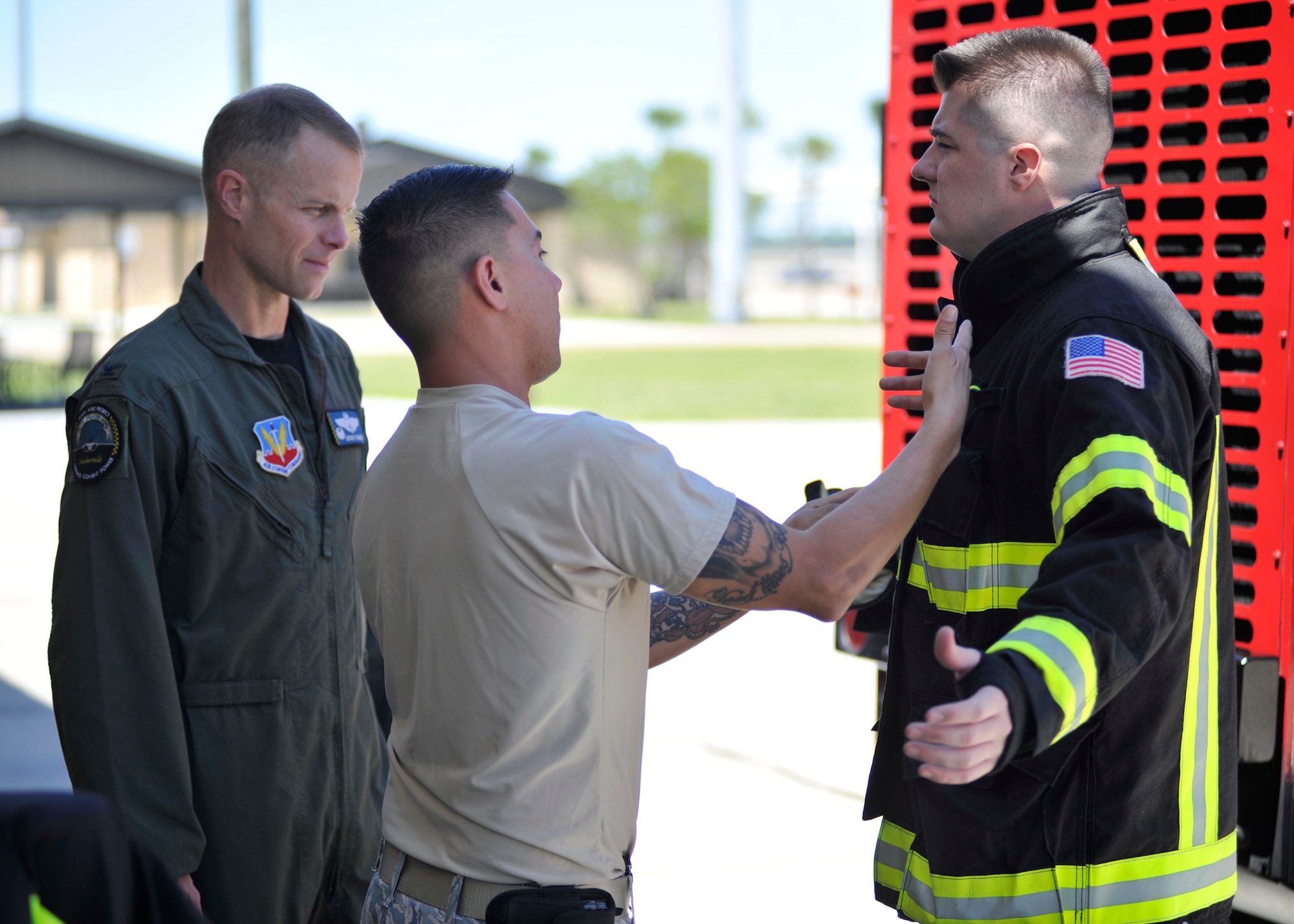 Staff Sgt. Jacob Banuelos, 325th Civil Engineer Squadron lead firefighter, shows Col. Derek C. France, 325th Fighter Wing commander, how to properly fit fire protection gear April 8, 2016. Banuelos was chosen by 325th Mission Support Group leadership to highlight his mission to France by showing him around the facility and training him on key aspects of the firefighting career field. (U.S. Air Force photo by Senior Airman Sergio A. Gamboa/Released)