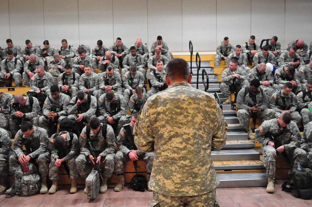 Chaplain (Capt.) Jamie Carson, standing, chaplain, Mobilization and Deployment, leads Soldiers assigned to the 307th Military Police Company in prayer during the farewell brief at the Silas L. Copeland Arrival/Departure Airfield Control Group here March 27.
