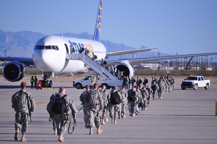 Soldiers Assigned to the 307th Military Police Company walk to and board the airplane that will take them to Guantanamo Naval Base, Cuba, March 27, at the Silas L. Copeland Arrival/Departure Airfield Control Group.