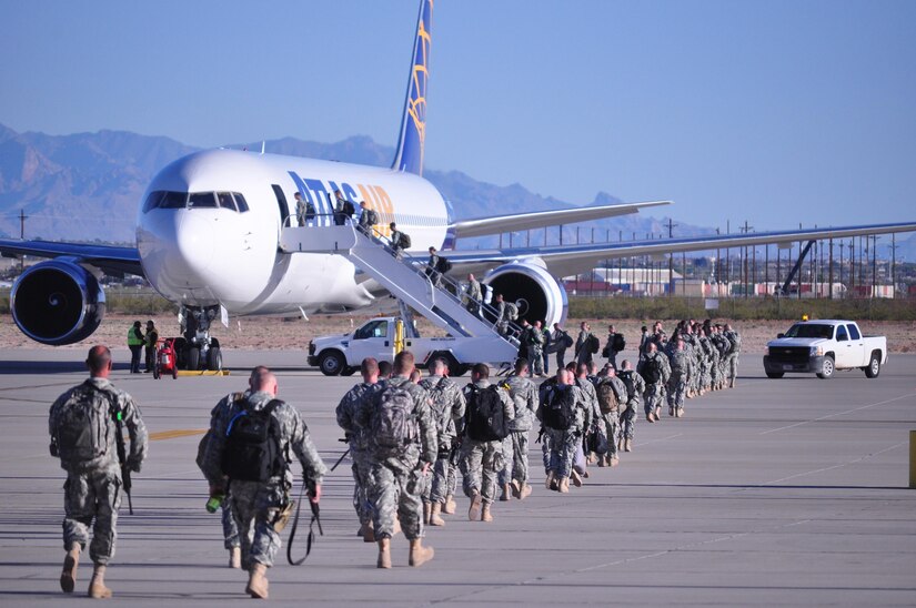 Soldiers Assigned to the 307th Military Police Company walk to and board the airplane that will take them to Guantanamo Naval Base, Cuba, March 27, at the Silas L. Copeland Arrival/Departure Airfield Control Group.