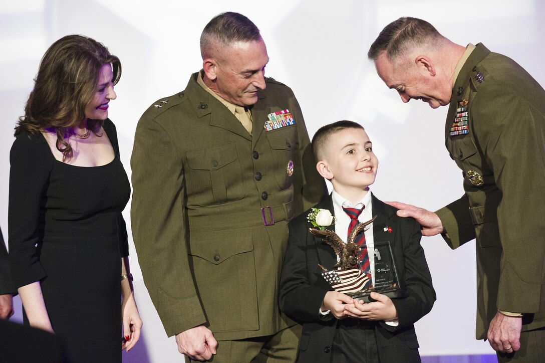Marine Corps Gen. Joe Dunford, right, chairman of the Joint Chiefs of Staff, congratulates Christian Fagala, 9, after he received a Military Child of the Year Award during a gala in Arlington, Va., April 14, 2016. DoD photo by Army Staff Sgt. Sean K. Harp