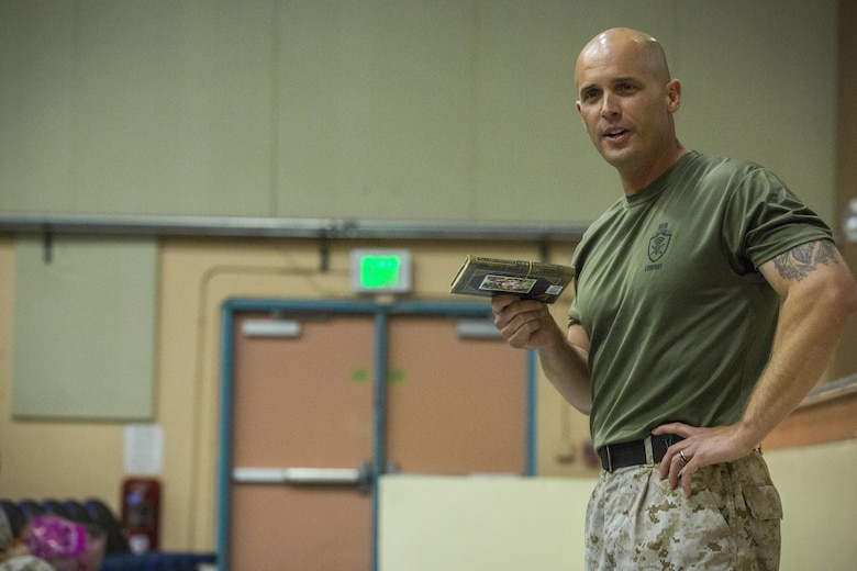 Maj. Chad E. Craven, outgoing company commander, Company D, Communication Training Battalion, Marine Corps Communication-Electronics School, displays “The Last Lecture” by Randy Pausch during the company’s change of command ceremony at the Combat Center theater April 1, 2016. During the ceremony, Craven gave the book as a present to Capt. Dimitri Stephanoff, oncoming company commander, to wish him well in his new position. (Official Marine Corps photo by Lance Cpl. Levi Schultz/Released)