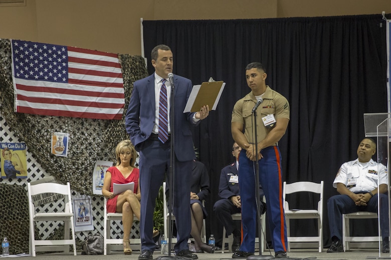Cpl. Stephen Garces, noncommissioned officer in charge of drafting and surveying, Marine Wing Support Squadron 374, listens as he is recognized by Tom Tucker, morning news anchor, CBS Local 2 News, during the 6th Annual Veteran’s Expo at the Riverside County Fairgrounds in Indio, Calif., April 2, 2016. (Official Marine Corps photo by Lance Cpl. Levi Schultz/Released)