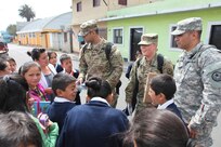 U.S. Army members are surrounded by school children and their teacher as they walk the streets to pass out flyers and educate the local population about a free medical clinic that will be provided by the U.S. military at Palo Gardo, Guatemala, March 29, 2016. Task Force Red Wolf and Army South conducts Humanitarian Civil Assistance Training to include tactical level construction projects and Medical Readiness Training Exercises providing medical access and building schools in Guatemala with the Guatemalan Government and non-government agencies from 05MAR16 to 18JUN16 in order to improve the mission readiness of US Forces and to provide a lasting benefit to the people of Guatemala. (U.S. Army photo by Sgt.Prosper Ndow/Released)