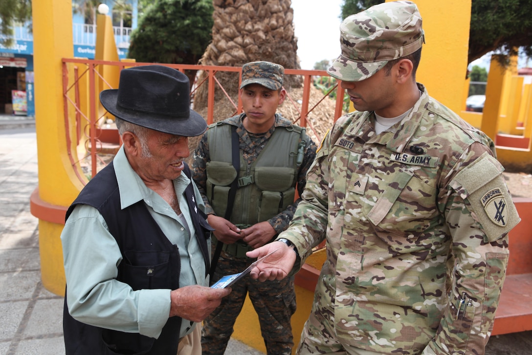 U.S. Army Cpl. Jonathan Soto with the 344th Psychological Operations hands out flyers and talks to locals about the upcoming free medical clinic that will be provided by the U.S. military at Palo Gordo, Guatemala, March 29, 2016. Task Force Red Wolf and Army South conducts Humanitarian Civil Assistance Training to include tactical level construction projects and Medical Readiness Training Exercises providing medical access and building schools in Guatemala with the Guatemalan Government and non-government agencies from 05MAR16 to 18JUN16 in order to improve the mission readiness of US Forces and to provide a lasting benefit to the people of Guatemala. (U.S. Army photo by Sgt. Prosper Ndow/Released)