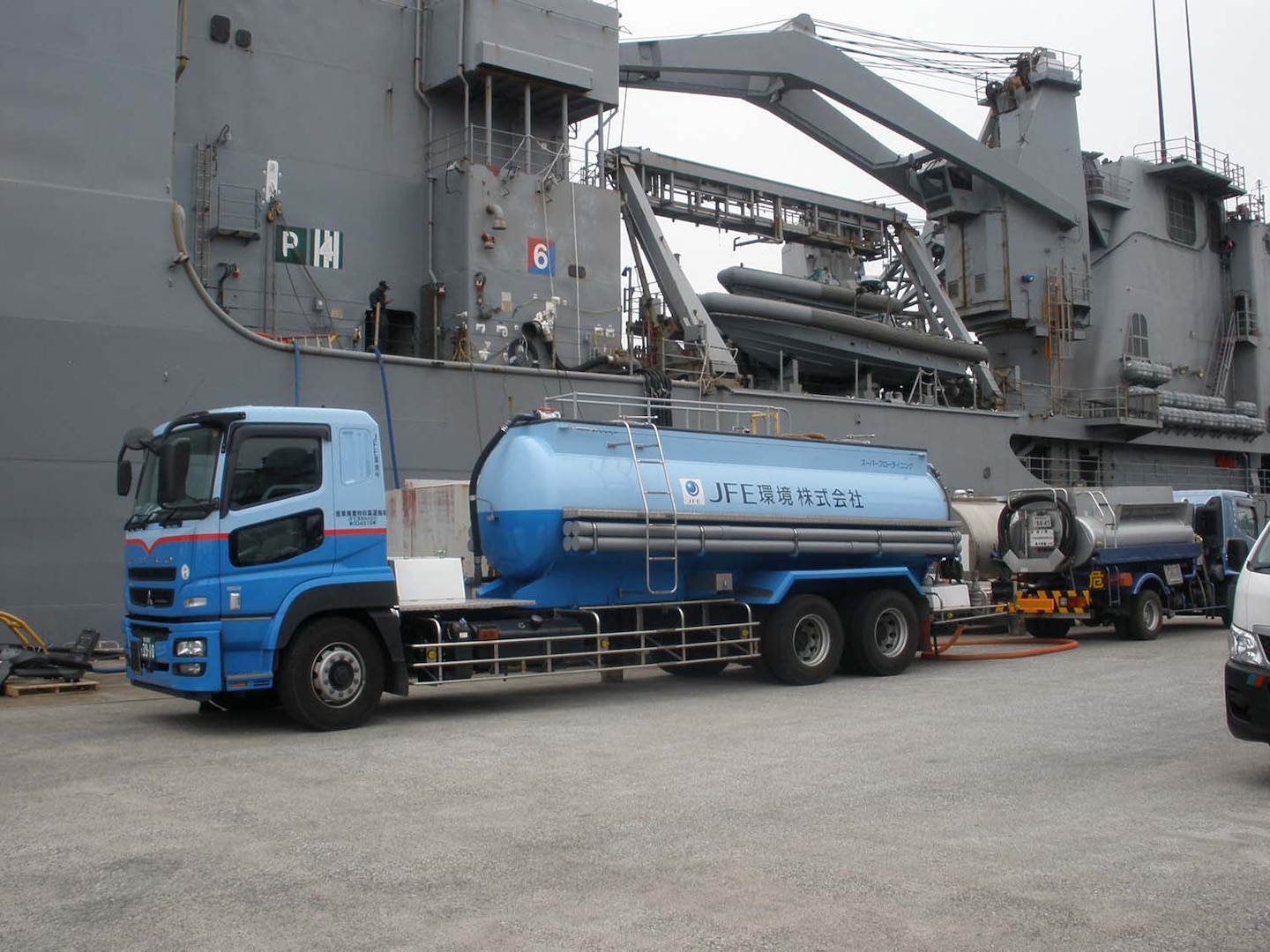 A truck from Japan Iron Engineering waits pier side to transport hazardous waste materials to a final disposal treatment storage facility.