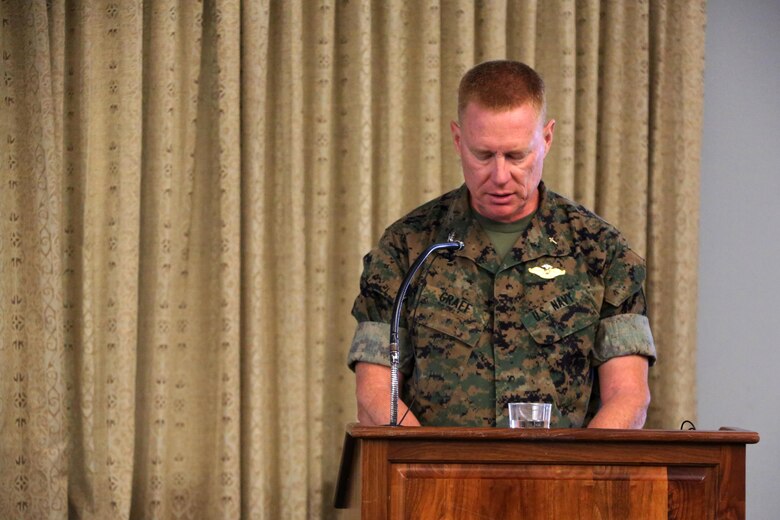 Navy Capt. Russell Graef conducts a prayer during a volunteer appreciation award ceremony at Marine Corps Air Station Cherry Point, N.C., April 12, 2016. The award ceremony was held to recognize the more than 90,000 volunteer hours collectively accomplished by members of the air station community. Senior leaders represented their units along with DOD employees and service family volunteers as they received individual recognition for their volunteer efforts and the positive impact they have on the air station. Graef is the 2nd Marine Aircraft Wing chaplain. (U.S. Marine Corps photo by Cpl. N.W. Huertas/Released)