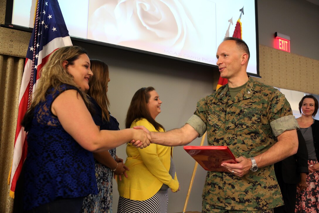 Col. Chris Pappas III (right) congratulates a volunteer during a volunteer appreciation ceremony at Marine Corps Air Station Cherry Point, N.C., April 12, 2016. The award ceremony was held for the more than 90,000 volunteer hours collectively accomplished by members of the air station community. Senior leaders represented their units, along with DOD employees and service family volunteers as they received individual recognition for their volunteer efforts and the positive impact they have on the air station. Pappas is the Cherry Point commanding officer. (U.S. Marine Corps photo by Cpl. N.W. Huertas/Released)