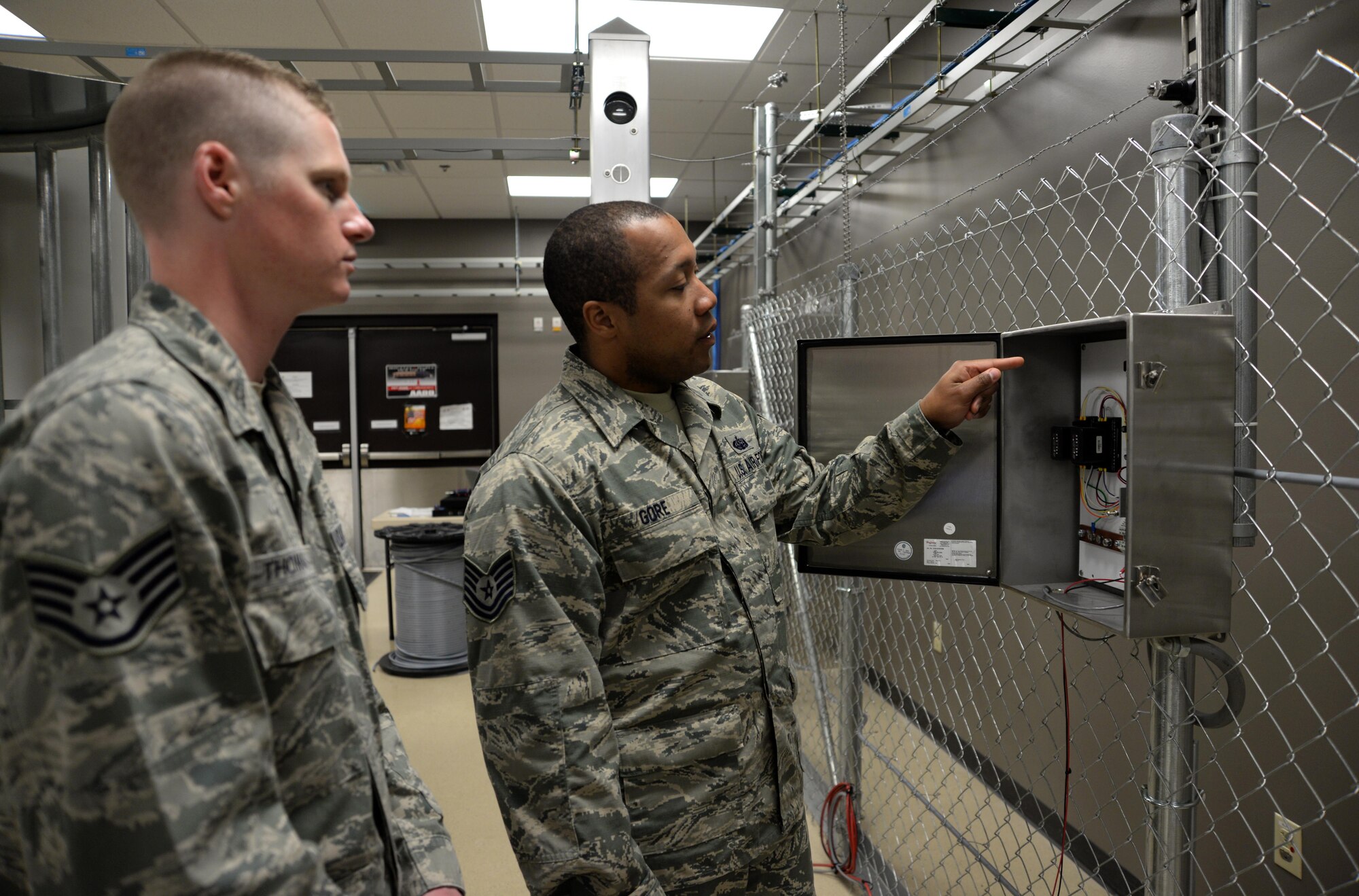 U.S. Air Force Tech. Sgt. Dexter Gore, right, the 509th Communications Squadron NCO in charge of intrusion detection systems, discusses a fiber optic security system in the Air Force Global Strike Command’s electronic security systems training lab with Staff Sgt. Robert Thomas, left, the 90th Communications Squadron NCO in charge of visual imagery and intrusion detection systems, at Whiteman Air Force Base, Mo.,  April 13, 2016. Eleven Airmen from the 90th Missile Wing spent six days at Whiteman exchanging information and ideas. 