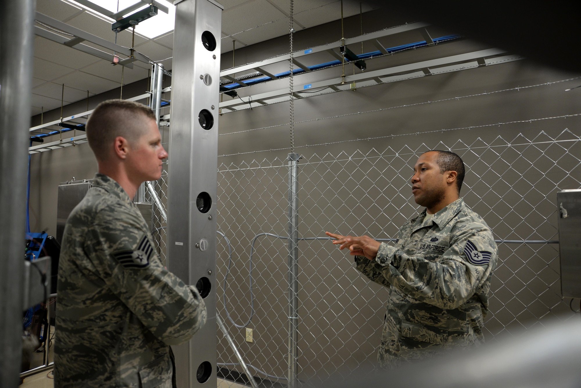 U.S. Air Force Tech. Sgt. Dexter Gore, right, the 509th Communications Squadron NCO in charge of intrusion detection systems, discusses an infrared perimeter intrusion detections system in the Air Force Global Strike Command’s electronic security systems training lab with Staff Sgt. Robert Thomas, left, the 90th Communications Squadron NCO in charge of visual imagery and intrusion detection systems, at Whiteman Air Force Base, Mo., April 13, 2016. Eleven Airmen from the 90th Missile Wing at F.E Warren Air Force Base, Wyo., participated in a sister wing exchange at Whiteman to connect and share information and ideas. 
