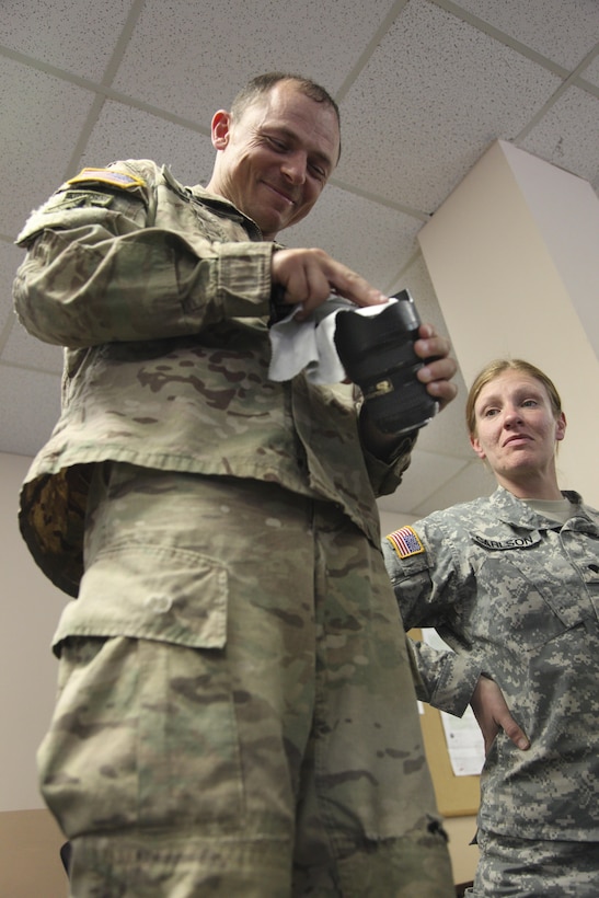 U.S. Army Staff Sgt. Alex Manne, assigned to the 982nd Combat Camera Company (Airborne) cleans his camera lens on Fort Gordon, Ga., April 12, 2016.  Operation Skyfall USA (OS-U) is a 982nd Combat Camera Company (Airborne) Theater Security Cooperation initiative. OS-U is a joint, multi-component, multi-lateral Combat Camera subject matter expert exchange taking place in multiple locations in Georgia. OS-U is part of a series that includes OS-Deutschland, OS-France, and OS-Kosovo. (U.S. Army photo by Spc. Joshua Wooten/Released)