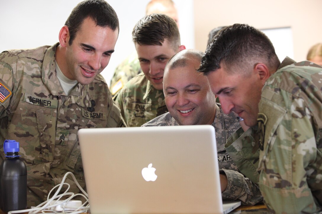 From the left, U.S. Army Sgt. Austin Berner, Spc. Michael Cox, Staff Sgt. Edward Reagan, and Staff Sgt. Justin Morelli, each assigned to the 982nd Combat Camera Company (Airborne), review photos captured during Operation Skyfall USA (OS-U) on Fort Gordon, Ga., April 12, 2016. OS-U is a 982nd Combat Camera Company (Airborne) Theater Security Cooperation initiative. OS-U is a joint, multi-component, multi-lateral Combat Camera subject matter expert exchange taking place in multiple locations in Georgia. OS-U is part of a series that includes OS-Deutschland, OS-France, and OS-Kosovo. (U.S. Army photo by Spc. Joshua Wooten/Released)