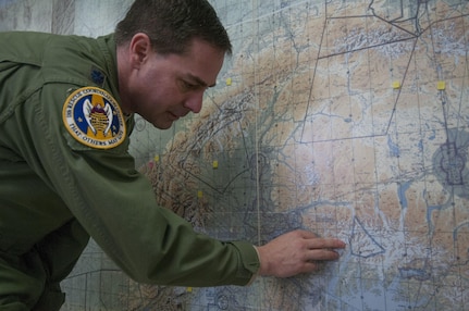 Lt. Col. John Morse, deputy director of the Alaska Rescue Coordination Center, points to the approximate location of three distressed climbers on a map at the RCC on Joint Base Elmendorf-Richardson, April 9, 2016. The climbers became stranded at 8,500 feet in elevation due to weather and signaled for help, which evoked the launch of a rescue effort by the Alaska Air National Guard. A few days later, two skiers were rescued.