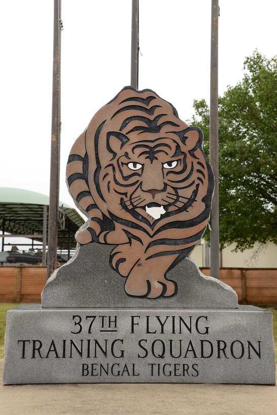 A statue and flagpoles depicting the 37th Flying Training Squadron mascot sits outside the building April 12 at Columbus Air Force Base, Mississippi. Before it was a training squadron, it was first established as the 37th Pursuit Squadron in January 1941, where it flew the P-38 Lightning I. (U.S. Air Force photo/Airman 1st Class John Day)