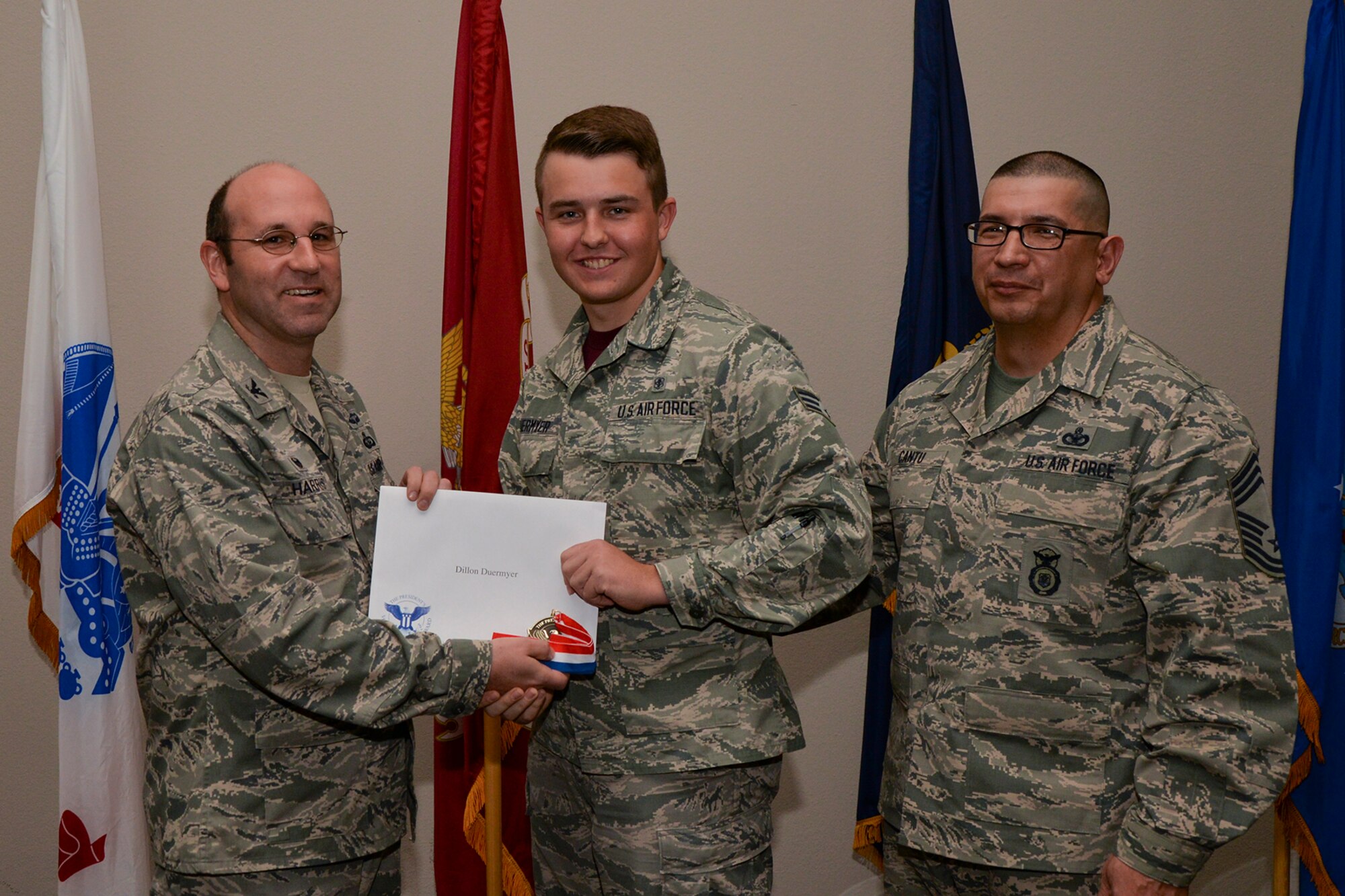 U.S. Air Force Col. Christopher Harris, 17th Mission Support Group Commander, and Chief Master Sgt. Jessie Cantu, 17th MSG acting superintendent, present the President’s Volunteer Service Award Bronze medal to Senior Airman Dillon Duermyer, 17th Medical Support Squadron, during the volunteer recognition ceremony at the Event Center on Goodfellow Air Force Base, Texas, April 15, 2016. The bronze medal is awarded to individuals who logged between 100 and 249 volunteer hours. (U.S. Air Force photo by Airman 1st Class Randall A.S. Moose/Released)