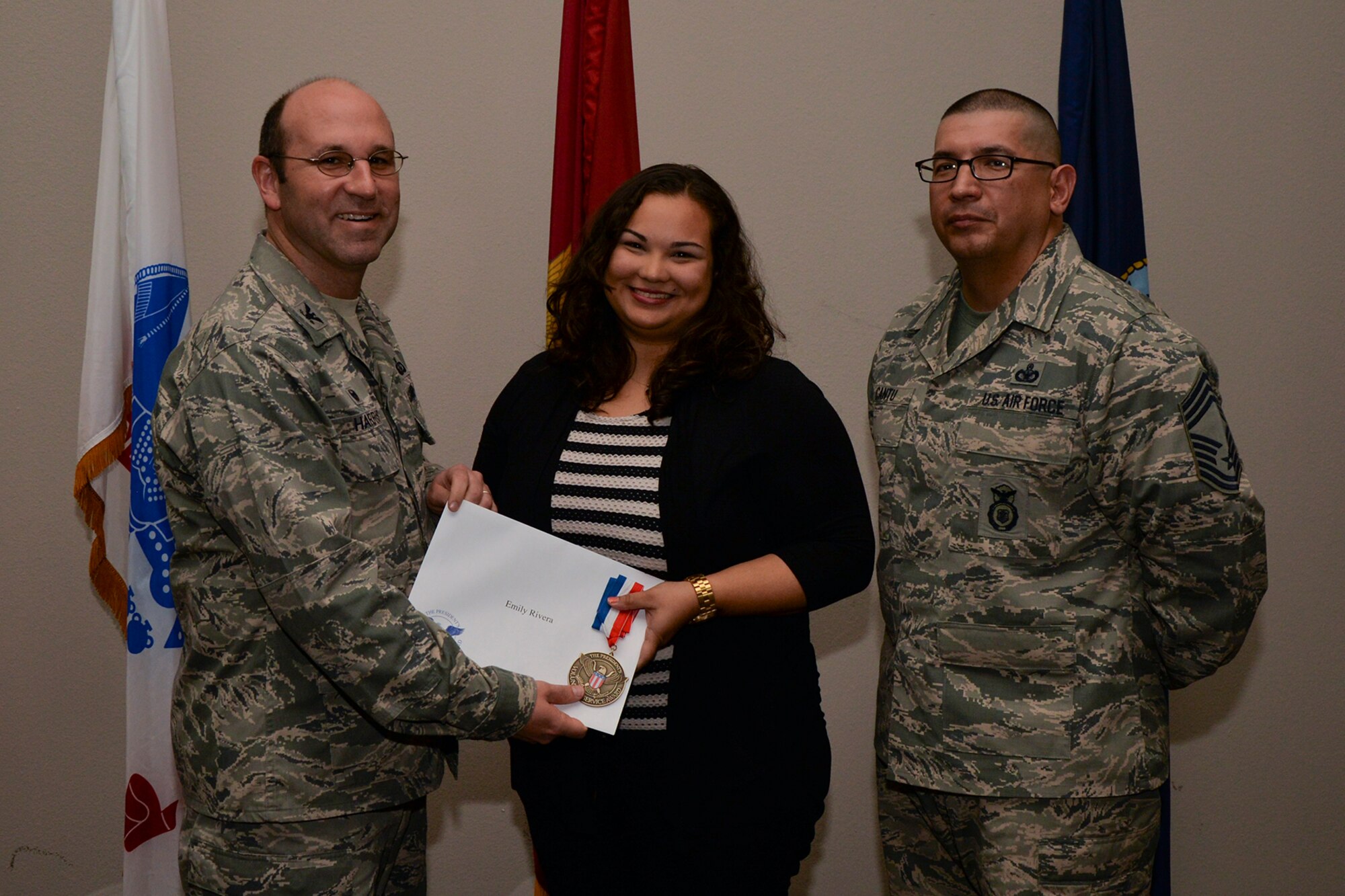 U.S. Air Force Col. Christopher Harris, 17th Mission Support Group Commander, and Chief Master Sgt. Jessie Cantu, 17th MSG acting superintendent, present the President’s Volunteer Service Award Bronze medal to Emily Rivera, 344th Military Intelligence Battalion, during the volunteer recognition ceremony at the Event Center on Goodfellow Air Force Base, Texas, April 15, 2016. The bronze medal is awarded to individuals who logged between 100 and 249 volunteer hours. (U.S. Air Force photo by Airman 1st Class Randall A.S. Moose/Released)
