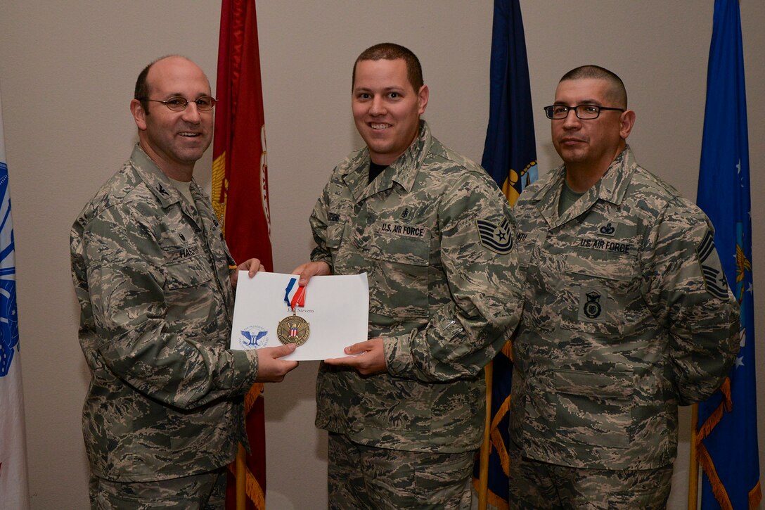 U.S. Air Force Col. Christopher Harris, 17th Mission Support Group Commander, and Chief Master Sgt. Jessie Cantu, 17th MSG acting superintendent, present the President’s Volunteer Service Award Bronze medal to Tech. Sgt. Joel Stevens, 17th Medical Support Squadron, during the volunteer recognition ceremony at the Event Center on Goodfellow Air Force Base, Texas, April 15, 2016. The bronze medal is awarded to individuals who logged between 100 and 249 volunteer hours. (U.S. Air Force photo by Airman 1st Class Randall A.S. Moose/Released)