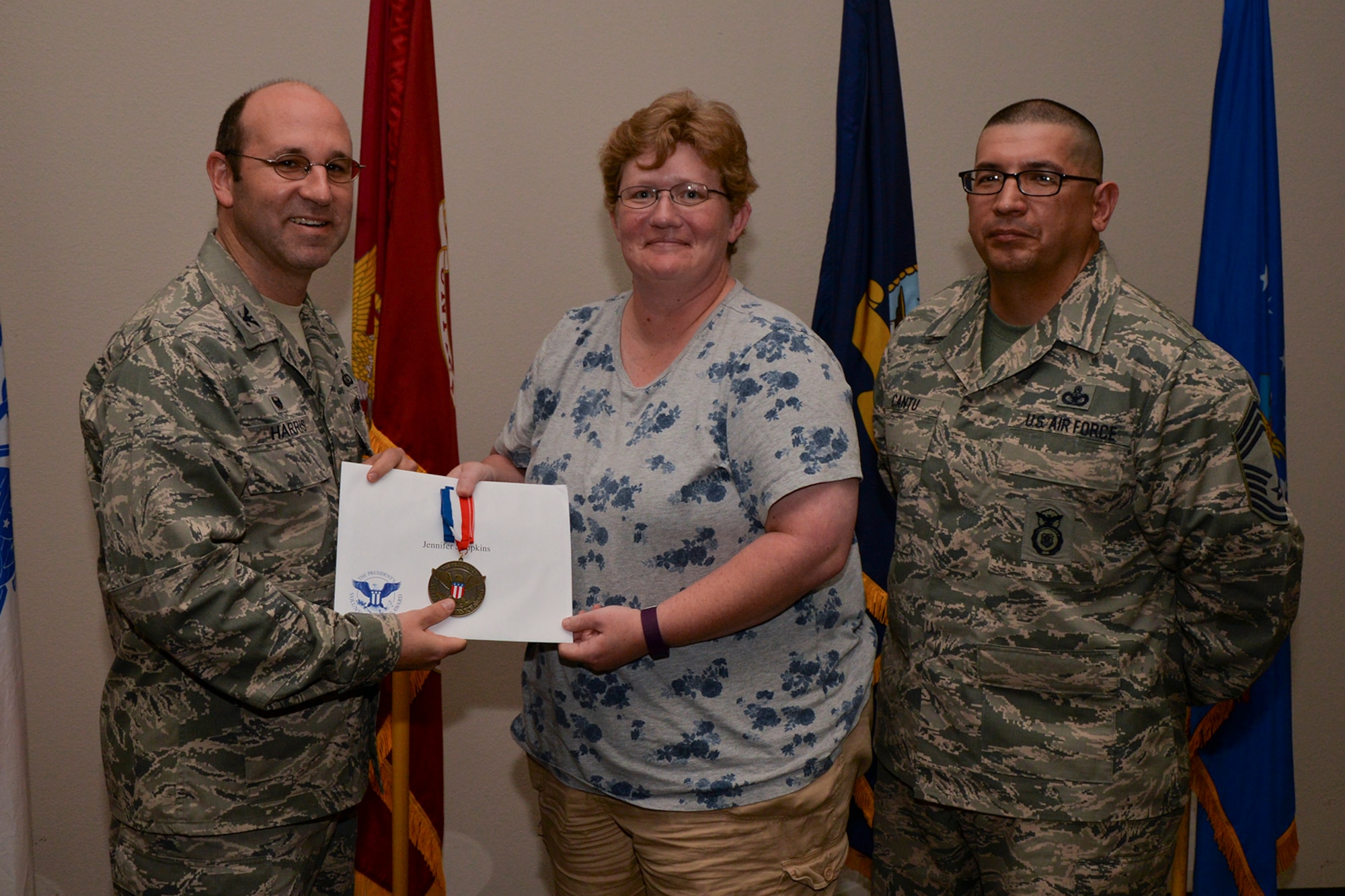 U.S. Air Force Col. Christopher Harris, 17th Mission Support Group Commander, and Chief Master Sgt. Jessie Cantu, 17th MSG acting superintendent, present the President’s Volunteer Service Award Bronze medal to Jennifer Simpkins, 17th Force Support Squadron, during the volunteer recognition ceremony at the Event Center on Goodfellow Air Force Base, Texas, April 15, 2016. The bronze medal is awarded to individuals who logged between 100 and 249 volunteer hours. (U.S. Air Force photo by Airman 1st Class Randall A.S. Moose/Released)