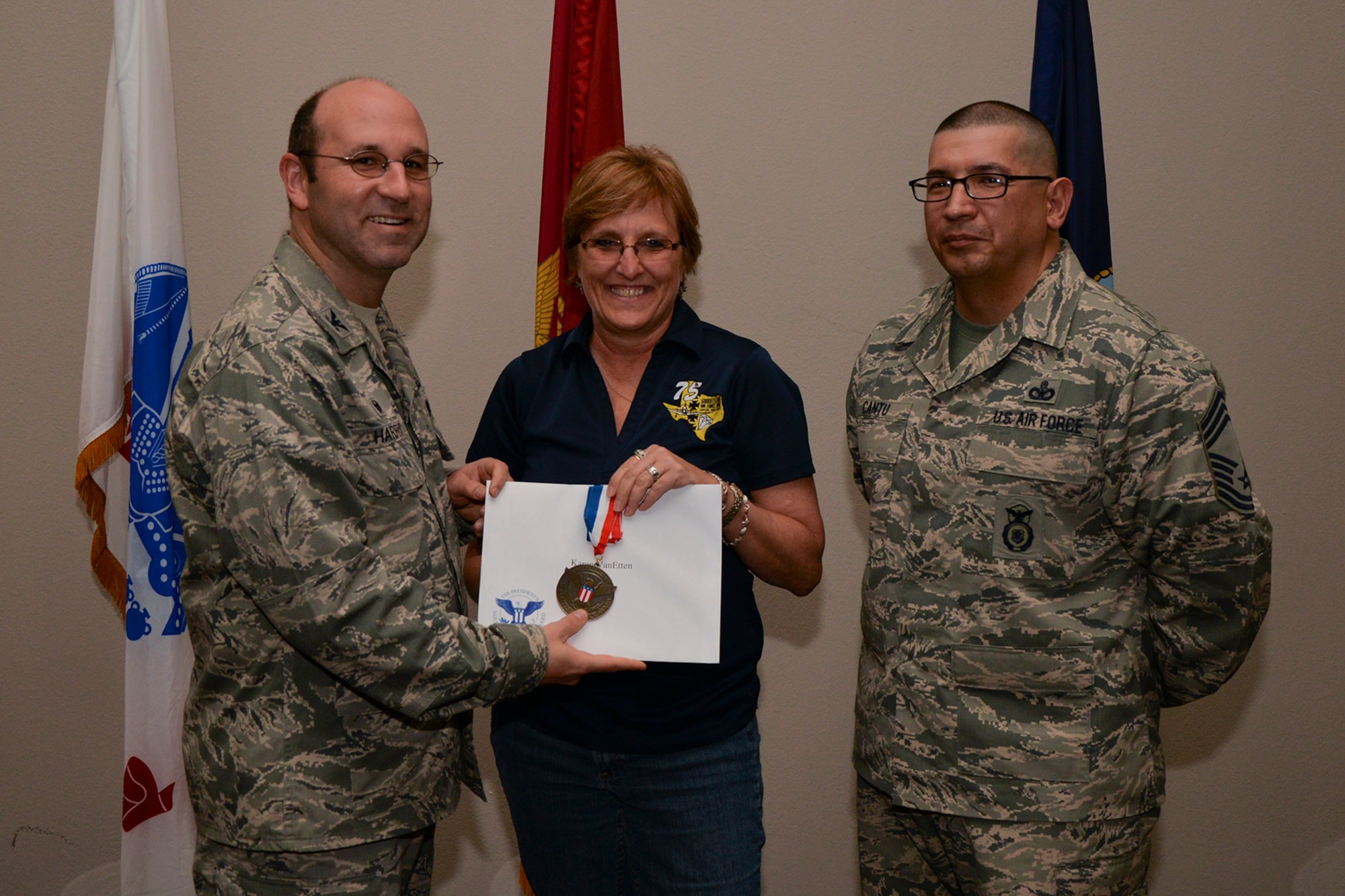 U.S. Air Force Col. Christopher Harris, 17th Mission Support Group Commander, and Chief Master Sgt. Jessie Cantu, 17th MSG acting superintendent, present the President’s Volunteer Service Award Bronze medal to Karen VanEtten, 17th Logistics Readiness Squadron, during the volunteer recognition ceremony at the Event Center on Goodfellow Air Force Base, Texas, April 15, 2016. The bronze medal is awarded to individuals who logged between 100 and 249 volunteer hours. (U.S. Air Force photo by Airman 1st Class Randall A.S. Moose/Released)