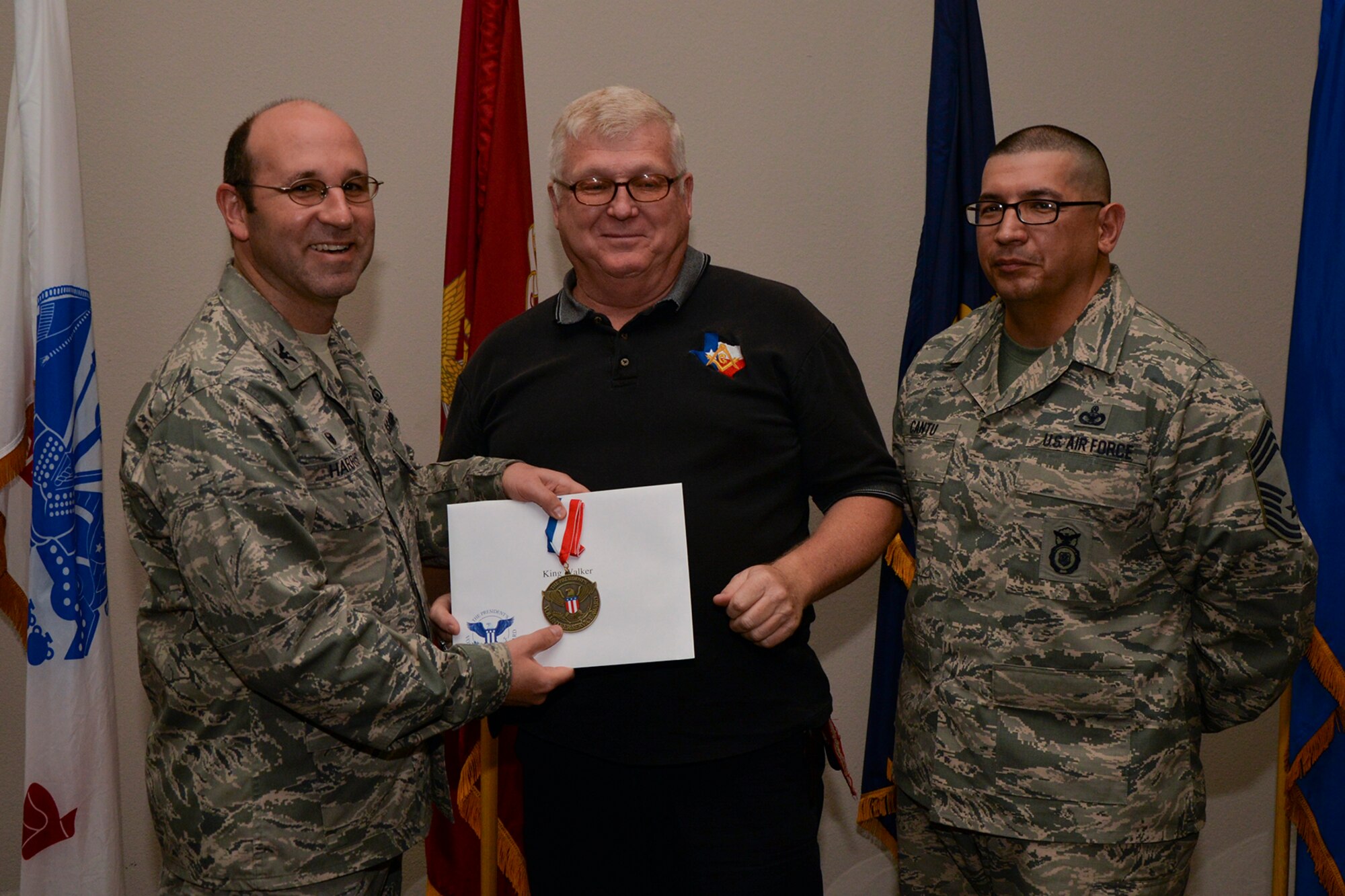 U.S. Air Force Col. Christopher Harris, 17th Mission Support Group Commander, and Chief Master Sgt. Jessie Cantu, 17th MSG acting superintendent, present the President’s Volunteer Service Award Bronze medal to King Walker, U.S. Army (retired), during the volunteer recognition ceremony at the Event Center on Goodfellow Air Force Base, Texas, April 15, 2016. The bronze medal is awarded to individuals who logged between 100 and 249 volunteer hours. (U.S. Air Force photo by Airman 1st Class Randall A.S. Moose/Released)