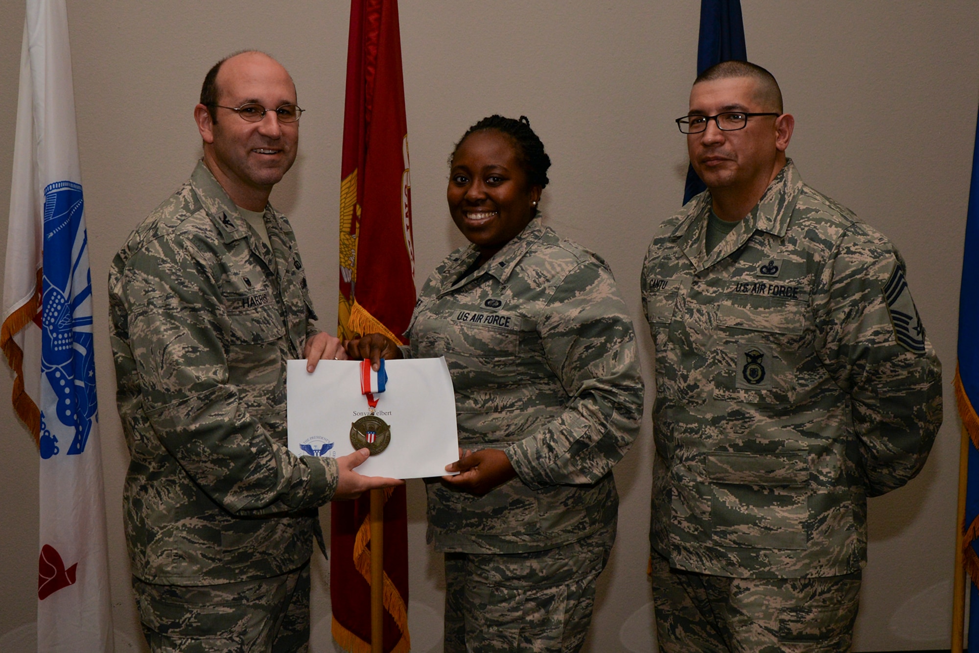 U.S. Air Force Col. Christopher Harris, 17th Mission Support Group Commander, and Chief Master Sgt. Jessie Cantu, 17th MSG acting superintendent, present the President’s Volunteer Service Award Bronze medal to 1st Lt. Sonya Yelbert, 17th Medical Support Squadron, during the volunteer recognition ceremony at the Event Center on Goodfellow Air Force Base, Texas, April 15, 2016. The bronze medal is awarded to individuals who logged between 100 and 249 volunteer hours. (U.S. Air Force photo by Airman 1st Class Randall A.S. Moose/Released)
