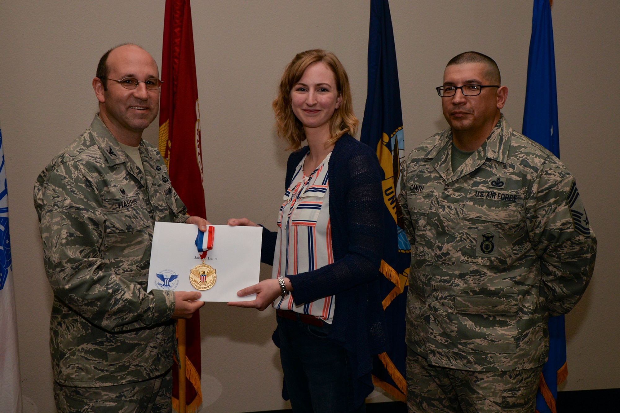 U.S. Air Force Col. Christopher Harris, 17th Mission Support Group Commander, and Chief Master Sgt. Jessie Cantu, 17th MSG acting superintendent, present the President’s Volunteer Service Award Gold medal to Janelle Lenn, 17th Training Support Squadron, during the volunteer recognition ceremony at the Event Center on Goodfellow Air Force Base, Texas, April 15, 2016. The gold medal is awarded to individuals who logged 500 or more volunteer hours. (U.S. Air Force photo by Airman 1st Class Randall A.S. Moose/Released)