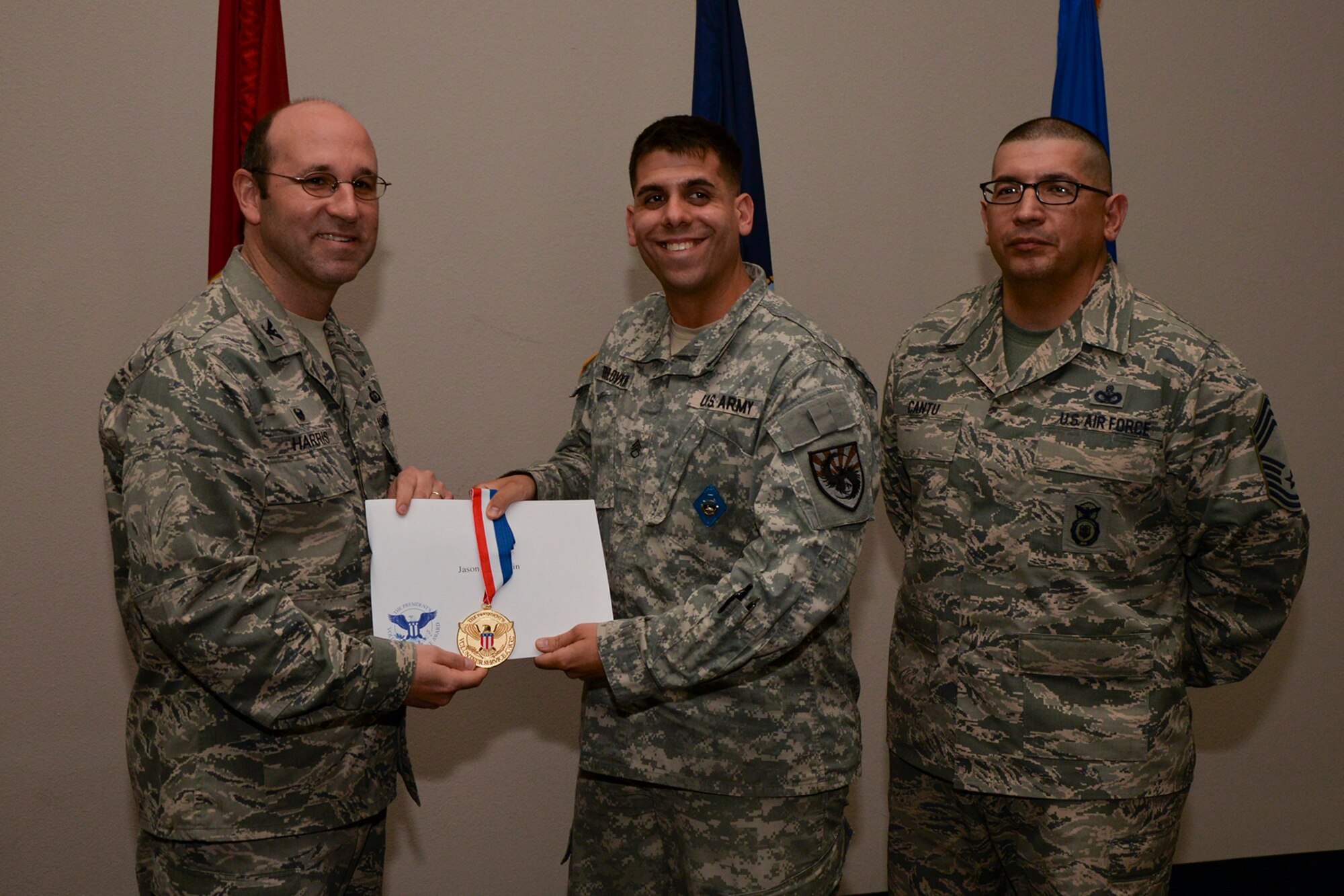 U.S. Air Force Col. Christopher Harris, 17th Mission Support Group Commander, and Chief Master Sgt. Jessie Cantu, 17th MSG acting superintendent, present the President’s Volunteer Service Award Gold medal to Staff Sgt. Jason Paulovkin, 344th Military Intelligence Battalion, during the volunteer recognition ceremony at the Event Center on Goodfellow Air Force Base, Texas, April 15, 2016. The gold medal is awarded to individuals who logged 500 or more volunteer hours. (U.S. Air Force photo by Airman 1st Class Randall A.S. Moose/Released)