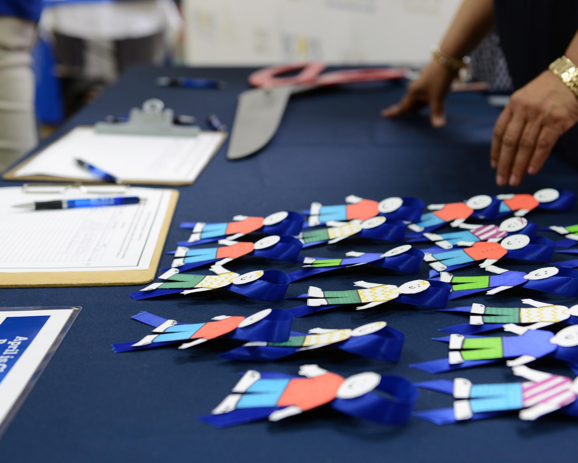 Miniature replicas of Cardboard Kids lay on a table at the Plaza Del Sol Mall in Del Rio, Texas, recently. Cardboard Kids are a representation of the children who suffer abuse and neglect every year. (U.S. Air Force photo by Senior Airman Jimmie D. Pike)