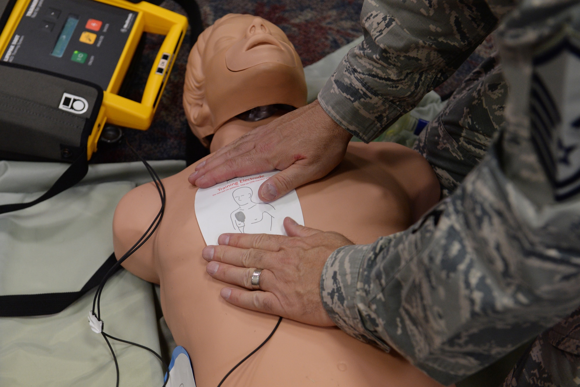 Master Sgt. Brent Harting, 932d Logistics Readiness Flight Log Plans NCOIC, places an automated external defibrillator on a practice mannequin during a basic life support class at the 375th Medical Group clinic April 6, 2016. Class attendees learned how to use an AED on a person going through a cardiac arrest, along with how to do chest compressions and breathe air into a person's lungs. (U.S. Air Force photo by Staff Sgt. Maria Bowman)