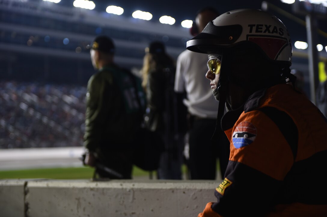 A pit crew member observes the race from behind the pit lane April 9, 2016, at the Texas Motor Speedway, Fort Worth, Texas. Forty racing teams and their drivers participated in the 334 lap, 501 mile-long race, and although the Air Force sponsored car did not race, the Air Force had a booth outside the speedway showcasing the race car. (U.S. Air Force photo by Senior Airman Alexander Guerrero/Released)