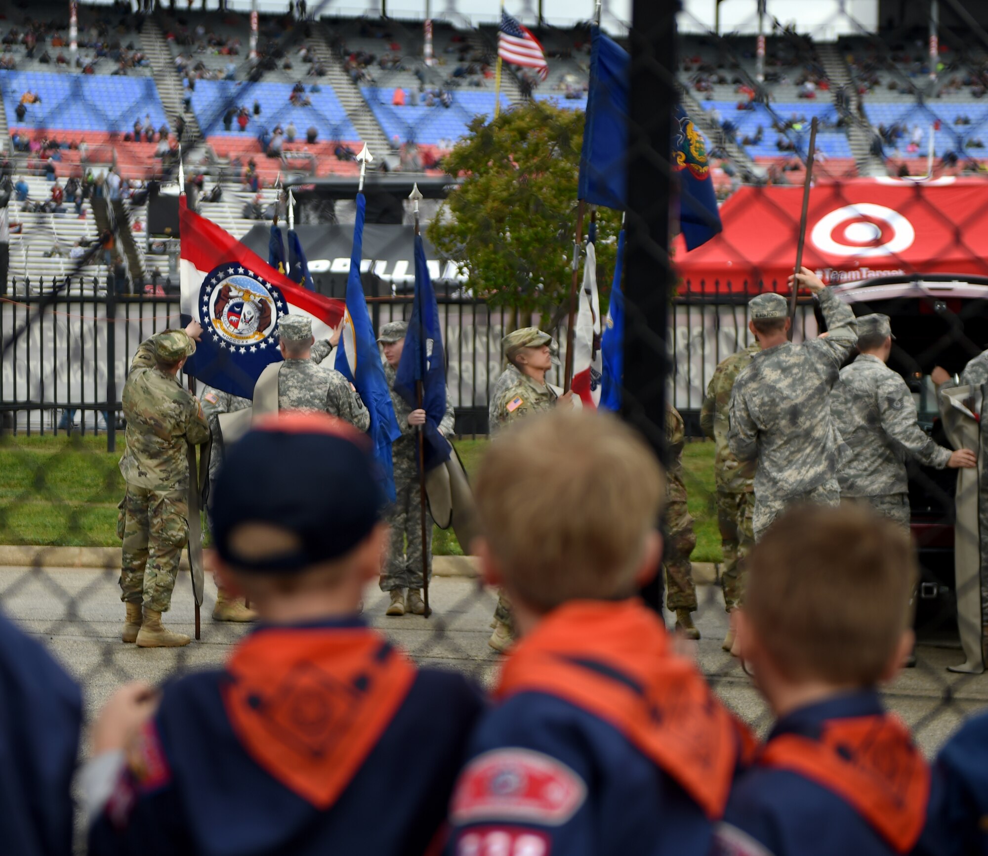 Boy Scouts of America watch U.S. Army Soldiers and U.S. Air Force Airmen prepare flags for the national anthem April 9, 2016, at the Texas Motor Speedway, Fort Worth, Texas. Soldiers and Airmen from different units and Boy Scouts from different troops participated in a flag ceremony during the playing of the national at the Duck Commander 500 NASCAR race. (U.S. Air Force photo by Senior Airman Alexander Guerrero/Released)