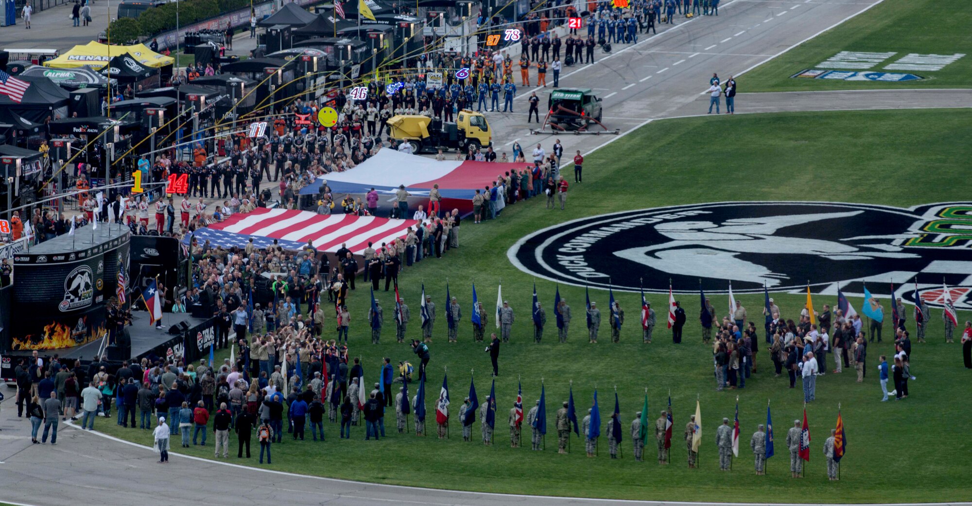 U.S. Air Force Airmen, U.S. Army Soldiers, members from Boy Scouts of America and volunteers all participated in a flag ceremony during the national anthem April 9, 2016, at the Texas Motor Speedway, Fort Worth, Texas. A large U.S. flag and a Texas state flag were held by the Boy Scouts and volunteers while Soldiers and Airmen held the U.S. state and territory flags. Gen. David L. Goldfein, United States Air Force vice chief of staff was also at the race to administer the oath of enlistment to men and women from a local Air Force Delayed Entry Program. (U.S. Air Force photo by Airman 1st Class Austin Mayfield/Released)