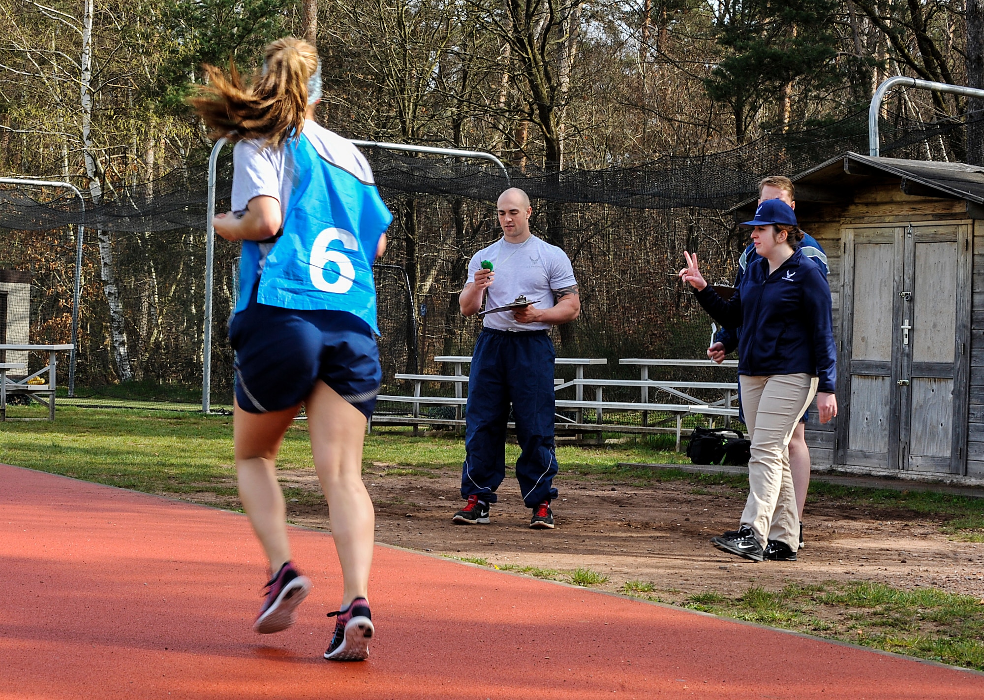 Physical training leaders keep track of Airmen’s run times during a fitness assessment April 12, 2016, at Ramstein Air Base, Germany. PTLs from different units assist the fitness assessment cell, allowing FAC Airmen to complete other duties such as answering questions, inputting test results and training unit fitness program managers and PTLs. (U.S. Air Force photo/Senior Airman Larissa Greatwood)