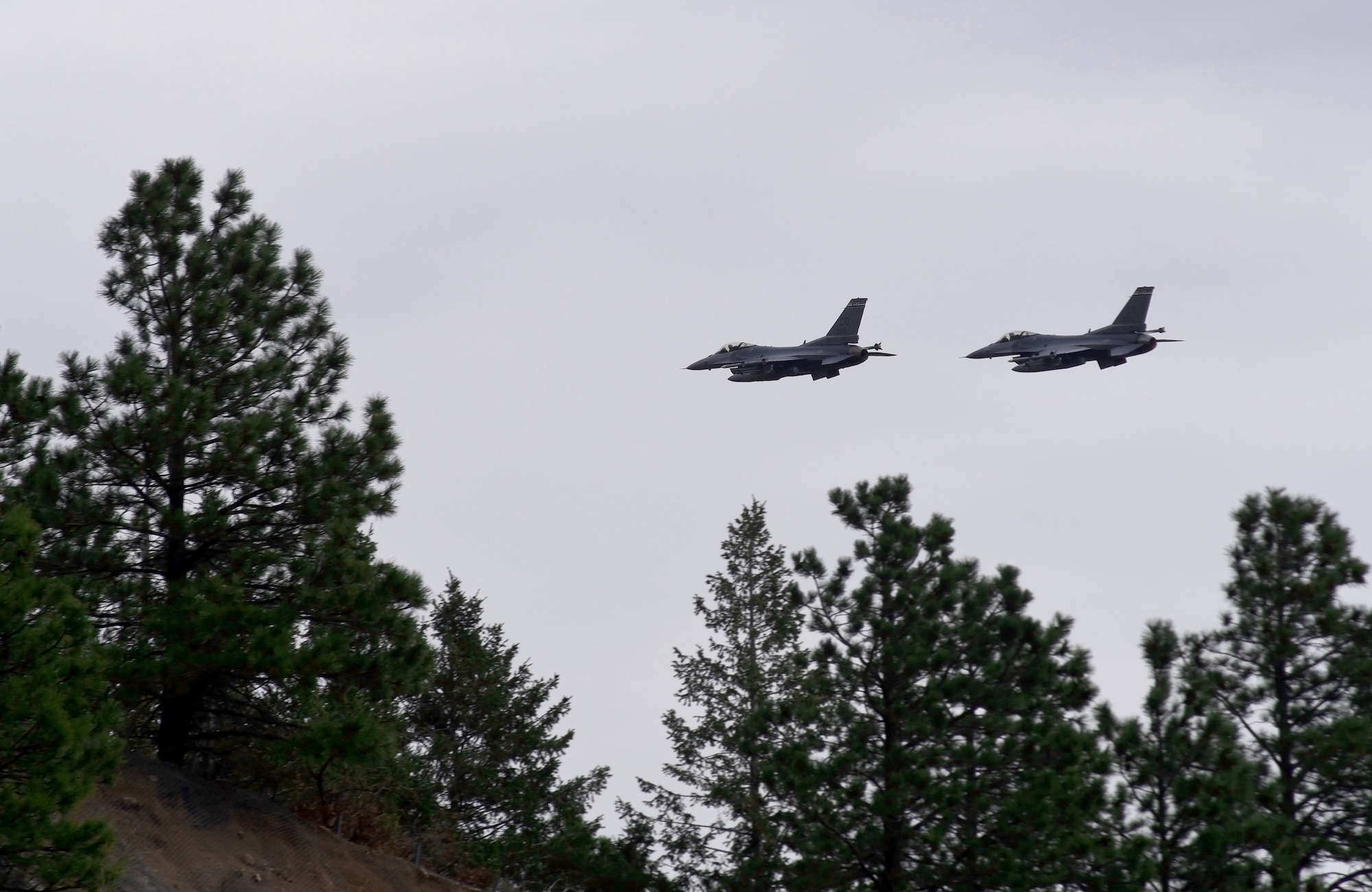 CHEYENNE MOUNTAIN AIR FORCE STATION, Colo. – Two F-16 Fighting Falcons, 140th Wing, Colorado Air National Guard perform a flyover during the 50th Anniversary Rededication Ceremony at Cheyenne Mountain Air Force Station April 15, 2016. Since its inception during the Cold War through the war on terrorism, Cheyenne Mountain has remained critical to the defense mission providing command and control for the nation since 1966. Cheyenne Mountain AFS is owned by the 21st Space Wing at Peterson Air Force Base, and operated by the 721st Mission Support Group. (U.S. Air Force photo by Airman 1st Class Dennis Hoffman)