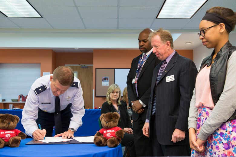Brig. Gen. Wayne Monteith, 45th Space Wing commander, signs a memorandum of agreement between Patrick Air Force Base and Brevard Schools April 15, 2016, at the Patrick AFB Youth Center, Florida. The agreement is designed to address the transition of military dependent students in a way that models and exemplifies partnership, flexibility, inclusiveness and information sharing for all schools that serve military dependent students. (U.S. Air Force photo by Matthew Jurgens/released)