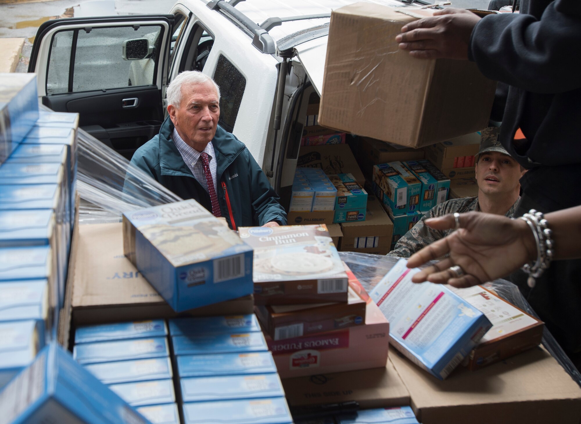 Robert Clagett, a food bank volunteer, and Capt. Carlos Cueto Diaz, Joint Base Andrews' food bank liaison, load donated goods into a vehicle prior to distribution at JBA, Maryland, April 7, 2016. In the last year, JBA has contributed nearly 10,000 pounds of food as part of the Defense Commissary Agency’s established process for covering diversion of unsellable but edible food to local food banks.  (Photo by Senior Airman Nesha Humes/RELEASED)