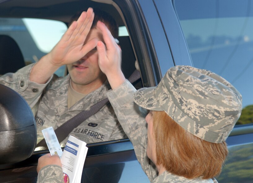 Col. Dawn Lancaster, left the hallowed halls of Bldg. 905  April 8, to do some of her best work – interacting with Team Robins members as they entered the base. Her personality was well received as she got high fives from a number of people. Lancaster, 78th Air Base Wing vice commander, is known for her hands-on approach and infectious attitude. (U.S. Air Force photo by Misuzu Allen)
