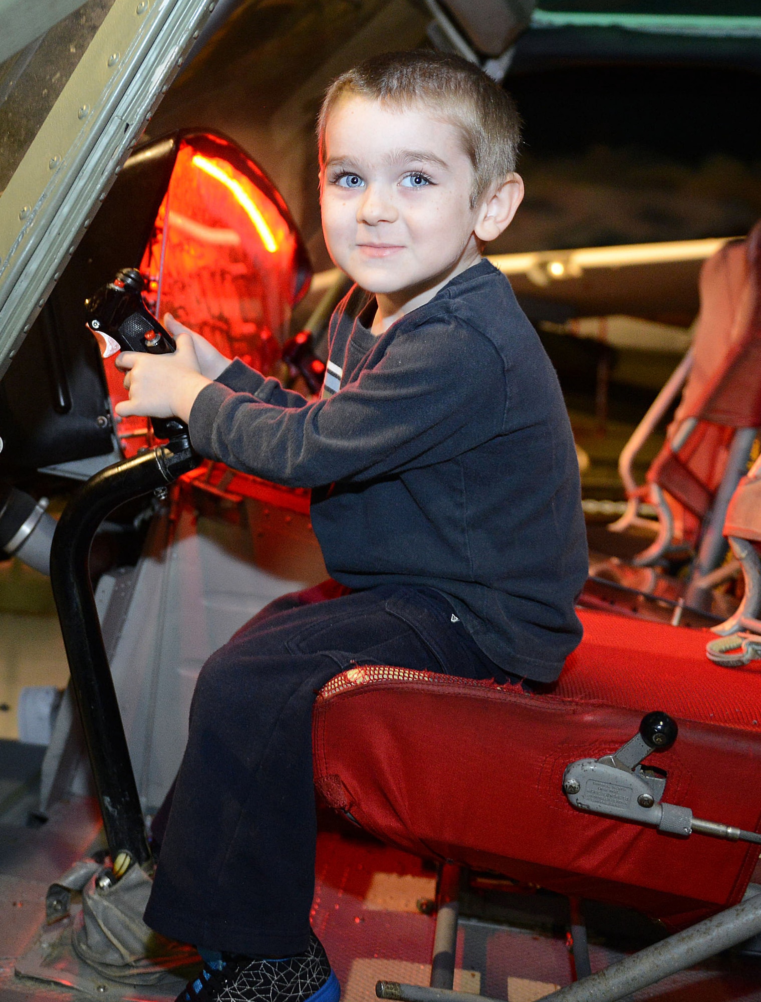 Silas Kain Ruest, 4, takes the pilot’s seat of a helicopter displayed in Hangar One. (U.S. Air Force photo by Tommie Horton)
