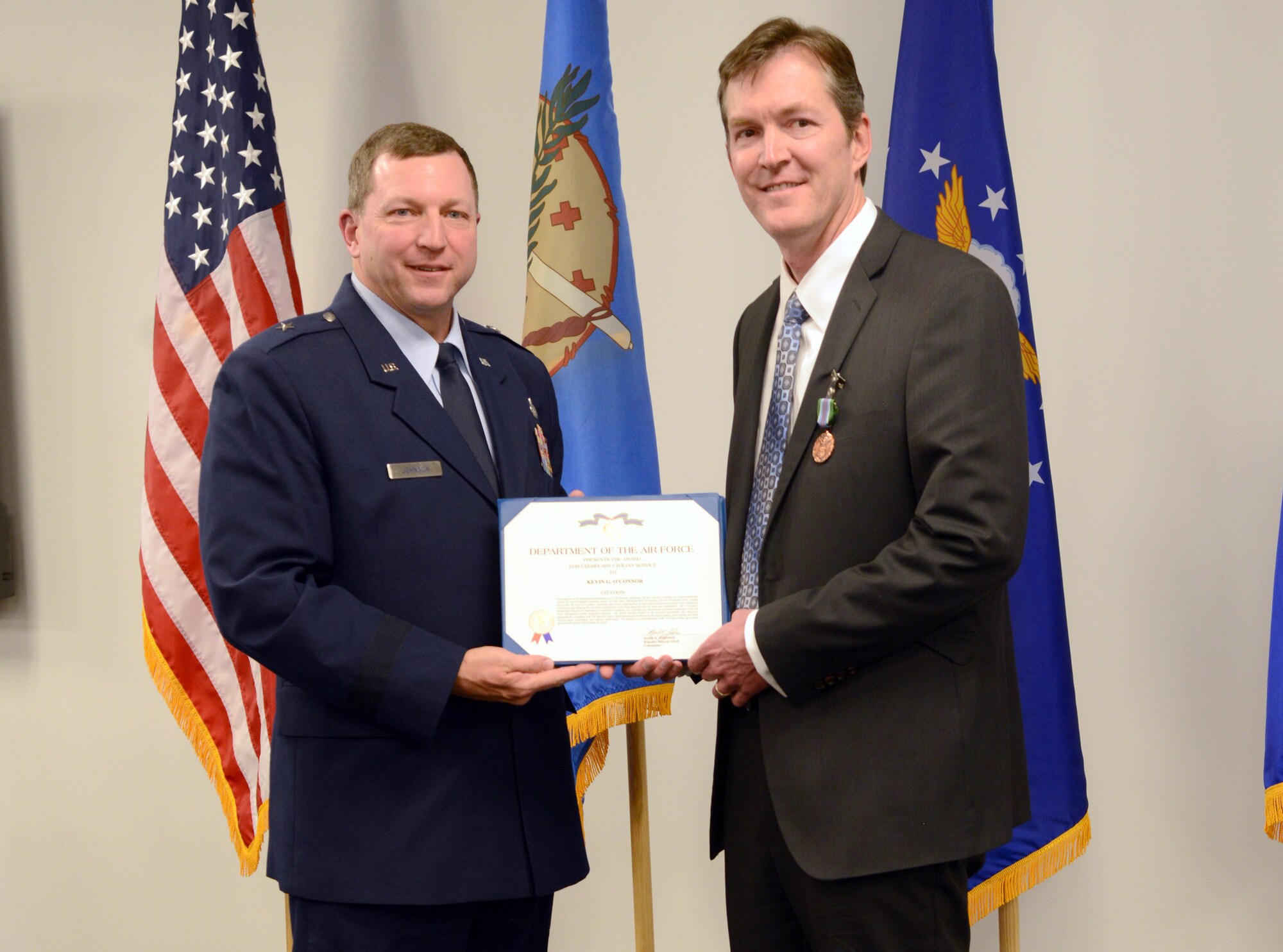 Oklahoma City Air Logistics Complex Commander Brig. Gen. Mark Johnson presents the Exemplary Civilian Service Award to Mr. Kevin O’Connor, former OC-ALC vice director, during his April 8 farewell reception at The Assembly in Bldg. 9001. After a 21-year civil service career with the United States Air Force, Mr. O’Connor has accepted a Senior Executive Service position with the Federal Aviation Administration. The ceremony also consisted of a friendly “roast” from Wade Wolfe, chief of the OC-ALC Business Operations Office, and a presentation of gifts from OC-ALC squadron directors. (Air Force photo by Kelly White/Released)