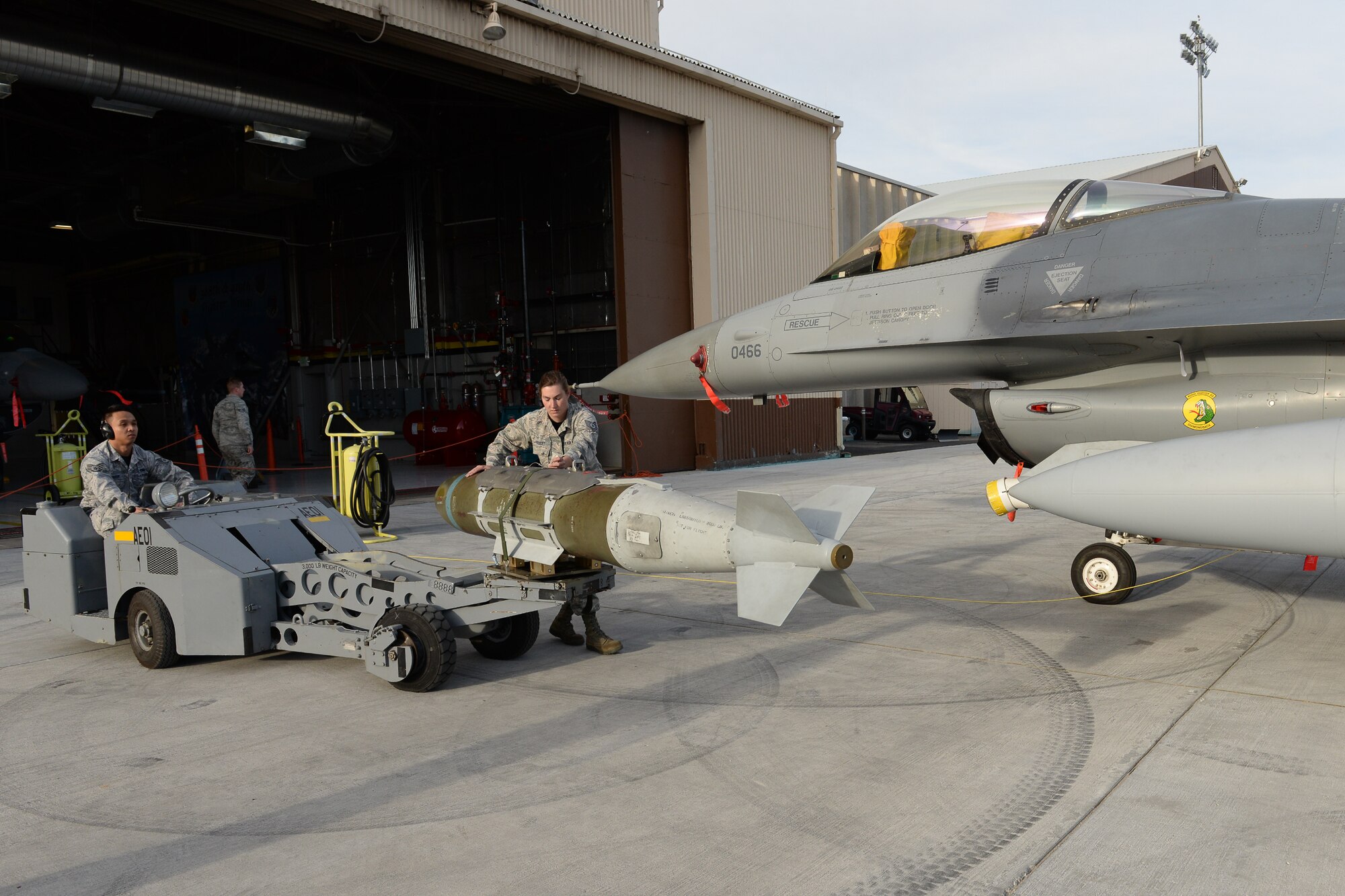 Tech. Sgt. Heidi Goulet and Staff Sgt. John Manayam, both assigned to the 466th Aircraft Maintenance Unit, guide a GBU-31 bomb toward the MAU-12 bomb rack on an F-16 aircraft April 8 at Hill Air Force Base, Utah. Goulet and Manayam, along with 466th AMU team member Staff Sgt. Heidi Limb, competed with three other AMUs during the 388th Fighter Wing’s quarterly weapons load competition. (U.S. Air Force photo by Paul Holcomb)